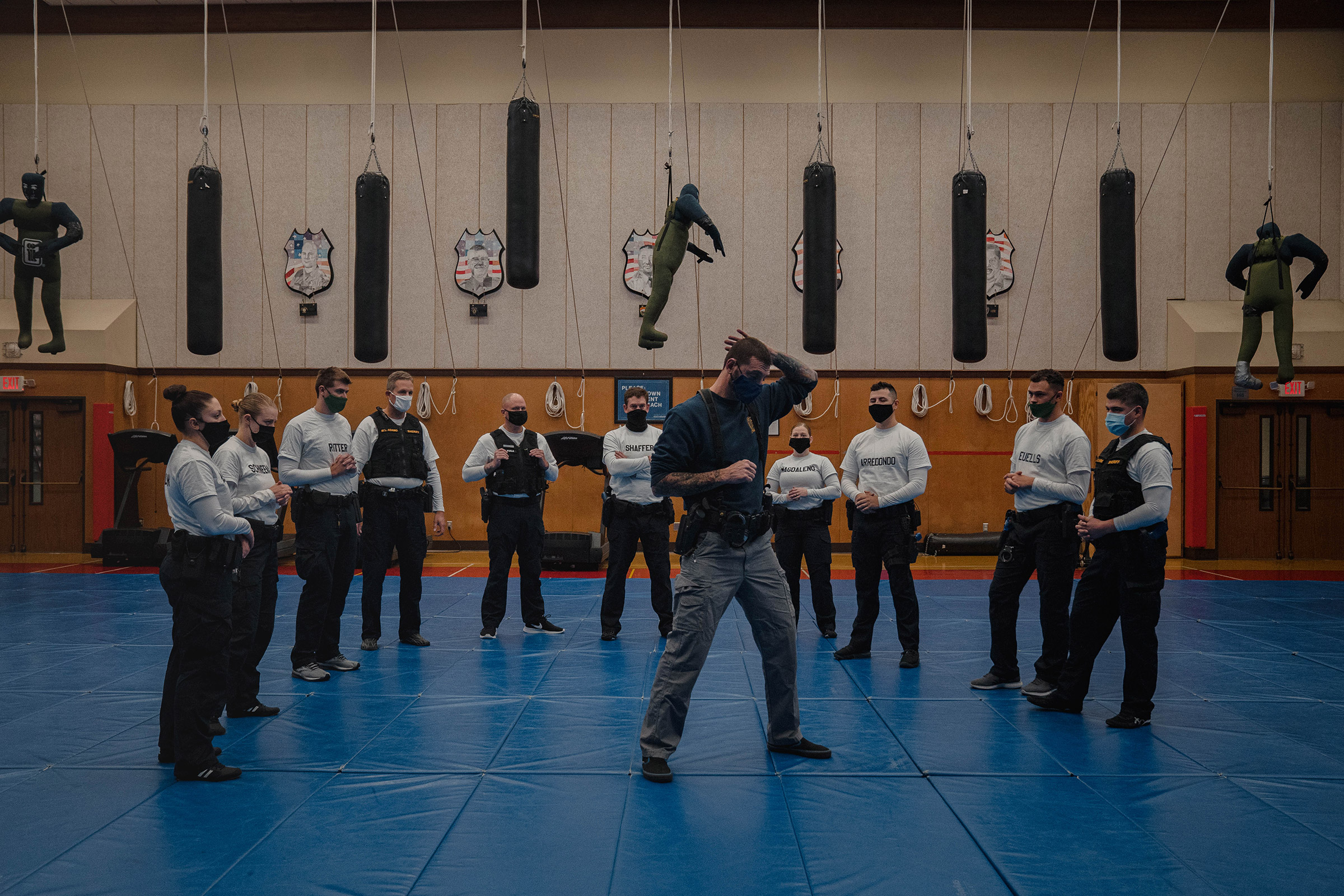 With punching bags and dummies overhead, instructor Javier Sola teaches frisking and handcuffing methods to police recruits at the Washington State Criminal Justice Training Commission facility in Burien, Wash., on Oct. 22. Washington State requires all 