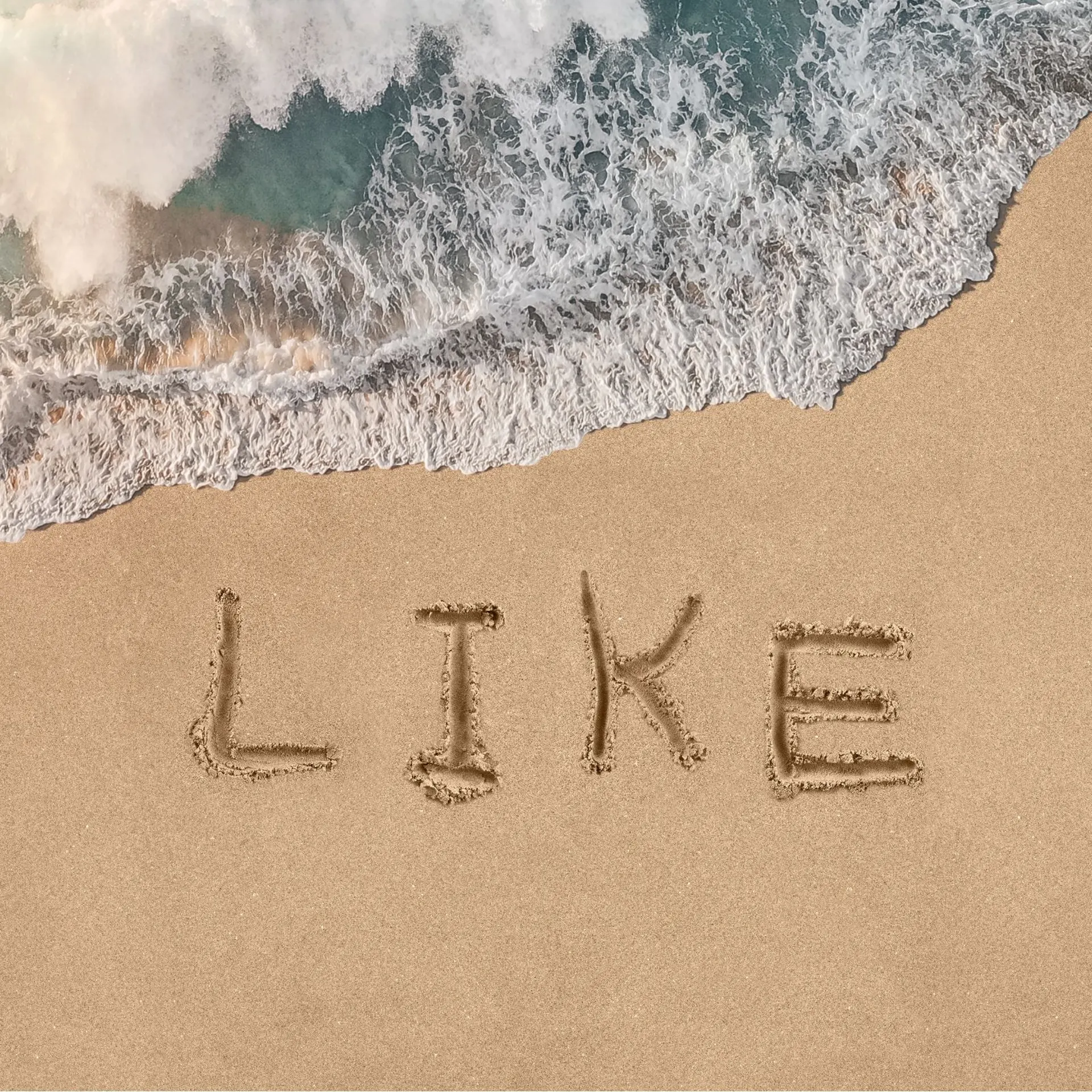 The word 'Like' written in the sand on a beach