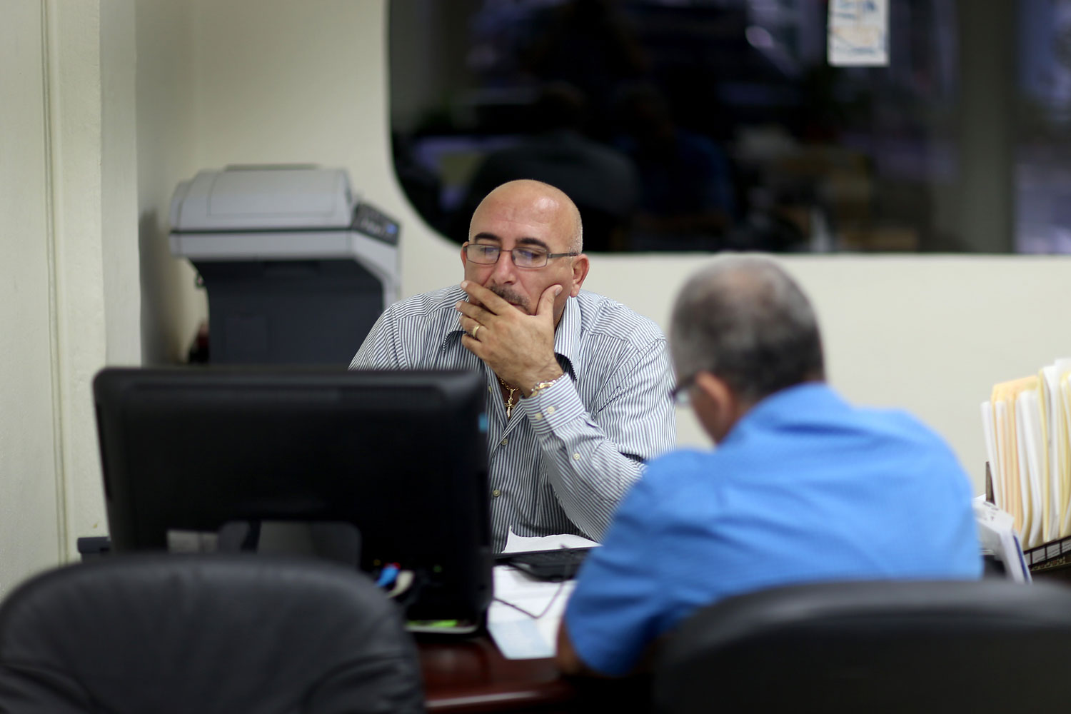 A. Michael Khoury at Leading Insurance Agency enrolls Hisham Uadadeh in a health insurance plan under the Affordable Care Act on Feb. 13, 2014 in Miami.