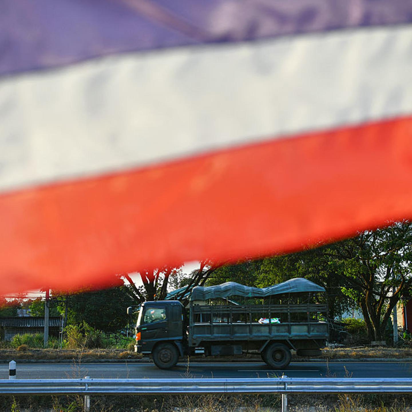 A Thai military vehicle passes by a Thai national flag in Kantharalak district in eastern Sisaket province on Dec. 30, 2025, after weeks of deadly border clashes between Thailand and Cambodia.