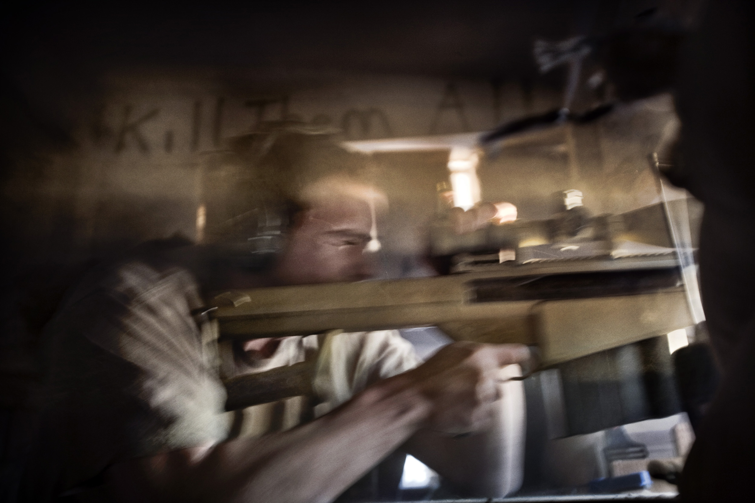 An American sniper fires upon an enemy location at the observation post Hotel Ramadi, Ramadi, Iraq, Nov. 18, 2005.