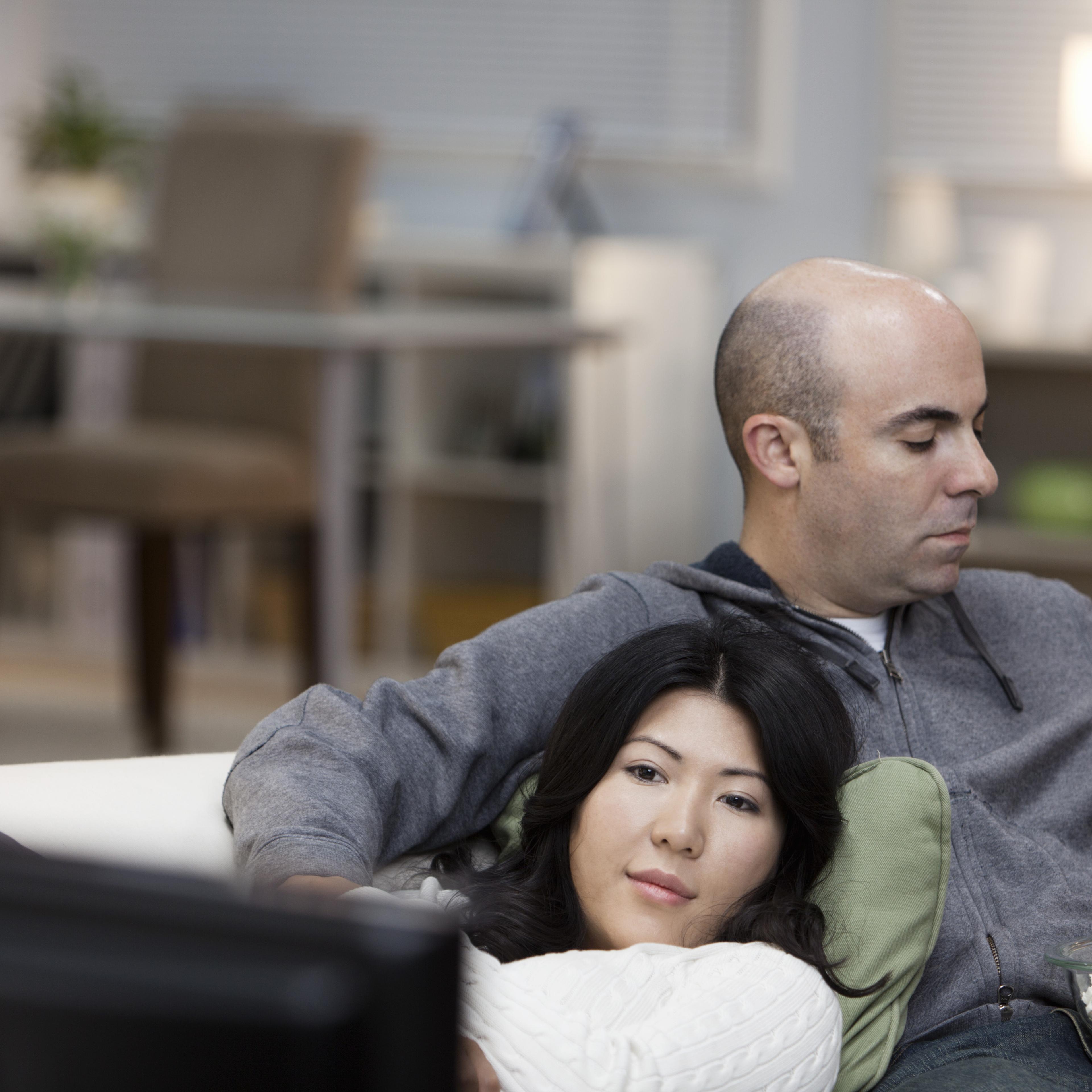 Couple on sofa watching television together