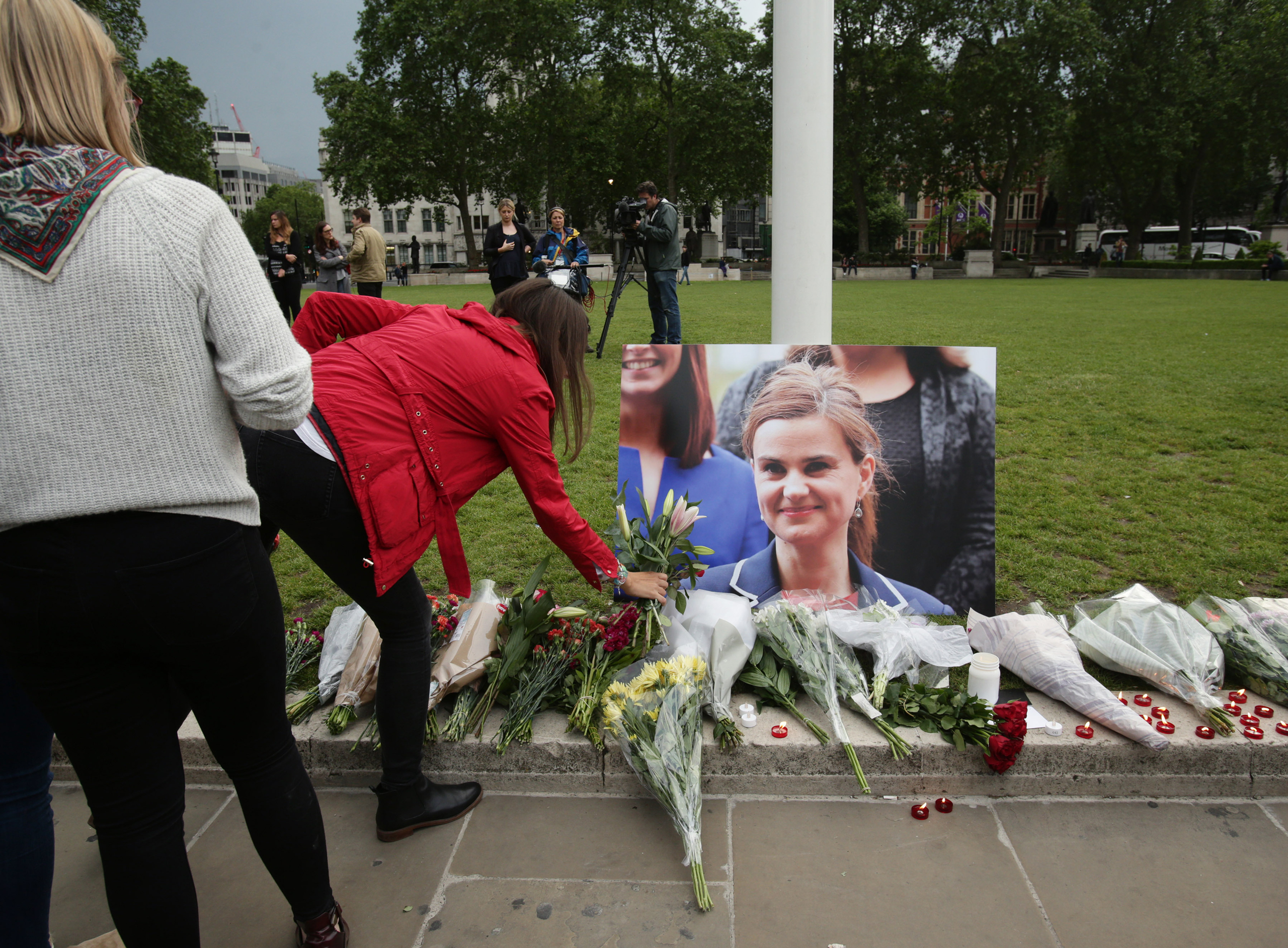 Jo Cox shooting. A woman lays some flowers at Parliament Square opposite the Palace of Westminster, central London, in tribute to Labour MP Jo Cox, who died after being shot and stabbed in the street outside her constituency advice surgery in Birstall, W