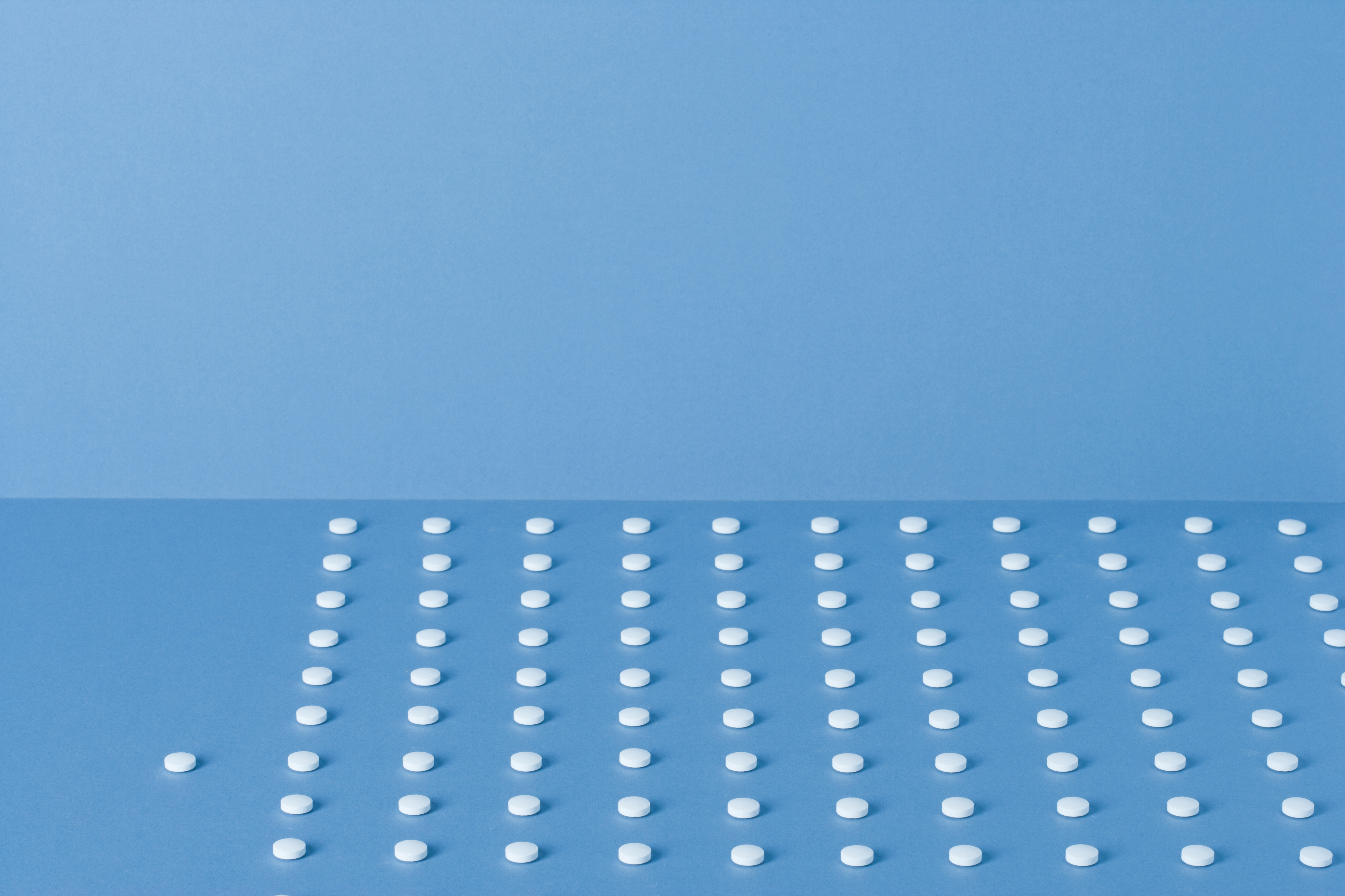 Pills lined up in rows with one beside TIME health stock