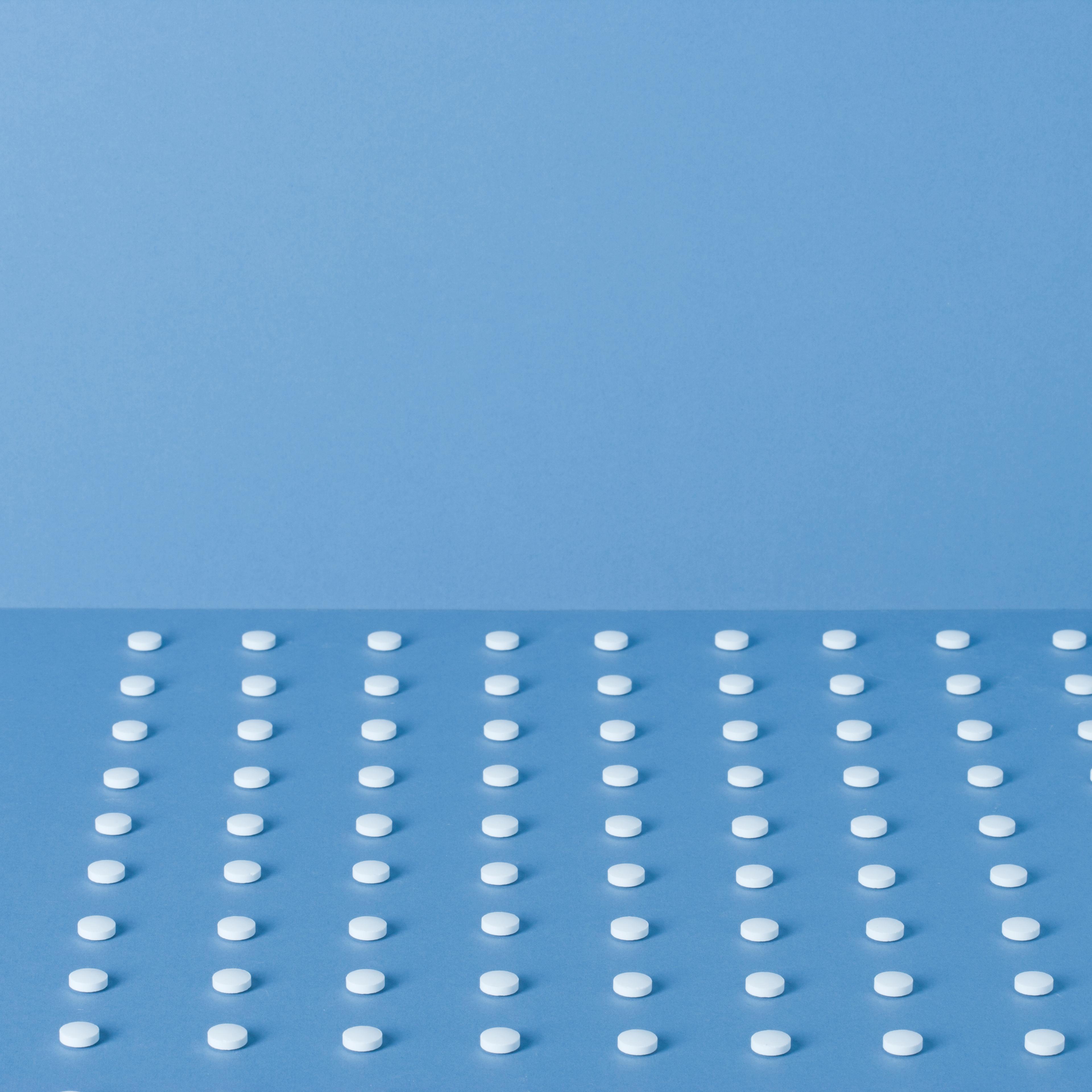 Pills lined up in rows with one beside TIME health stock