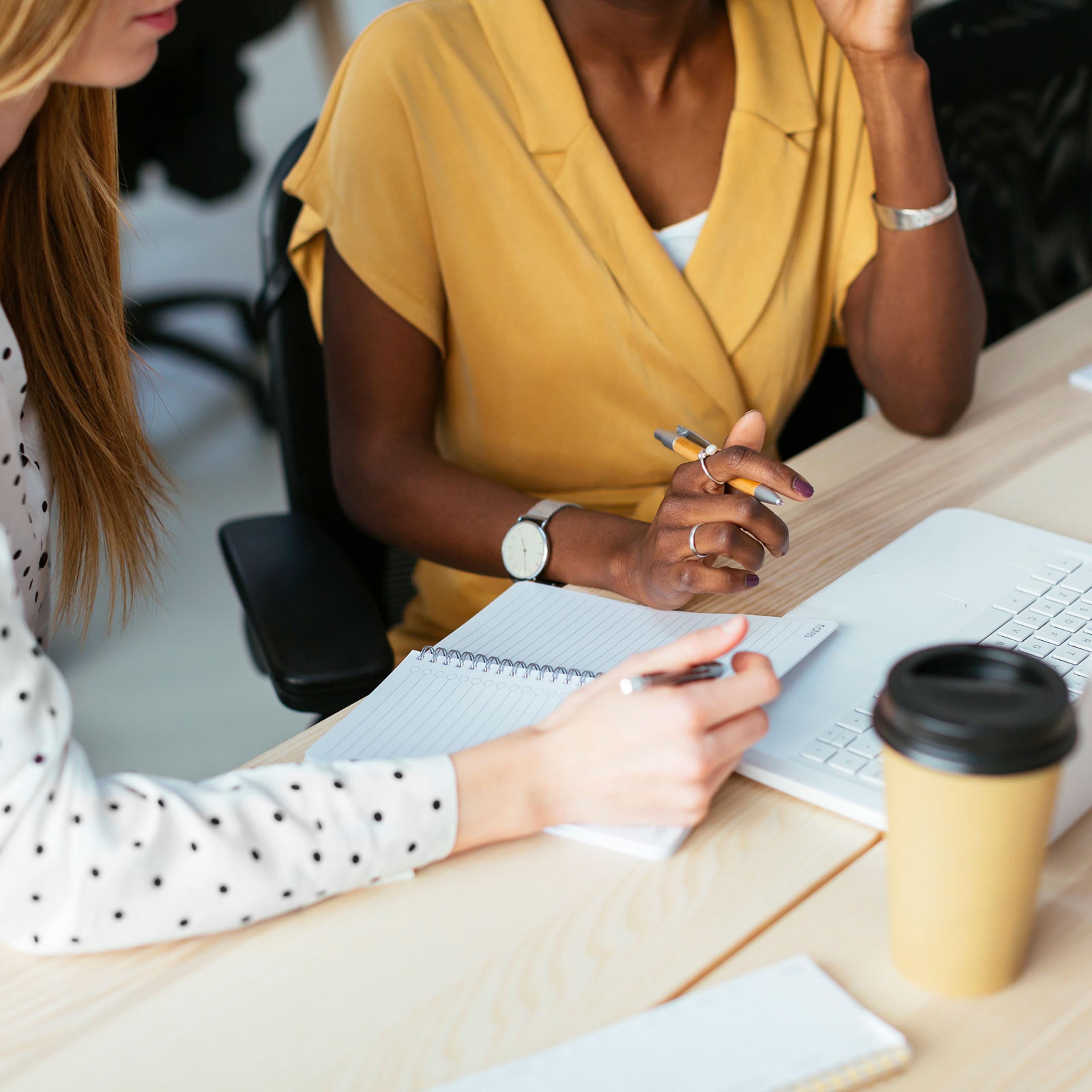 Colleagues working together at desk in office