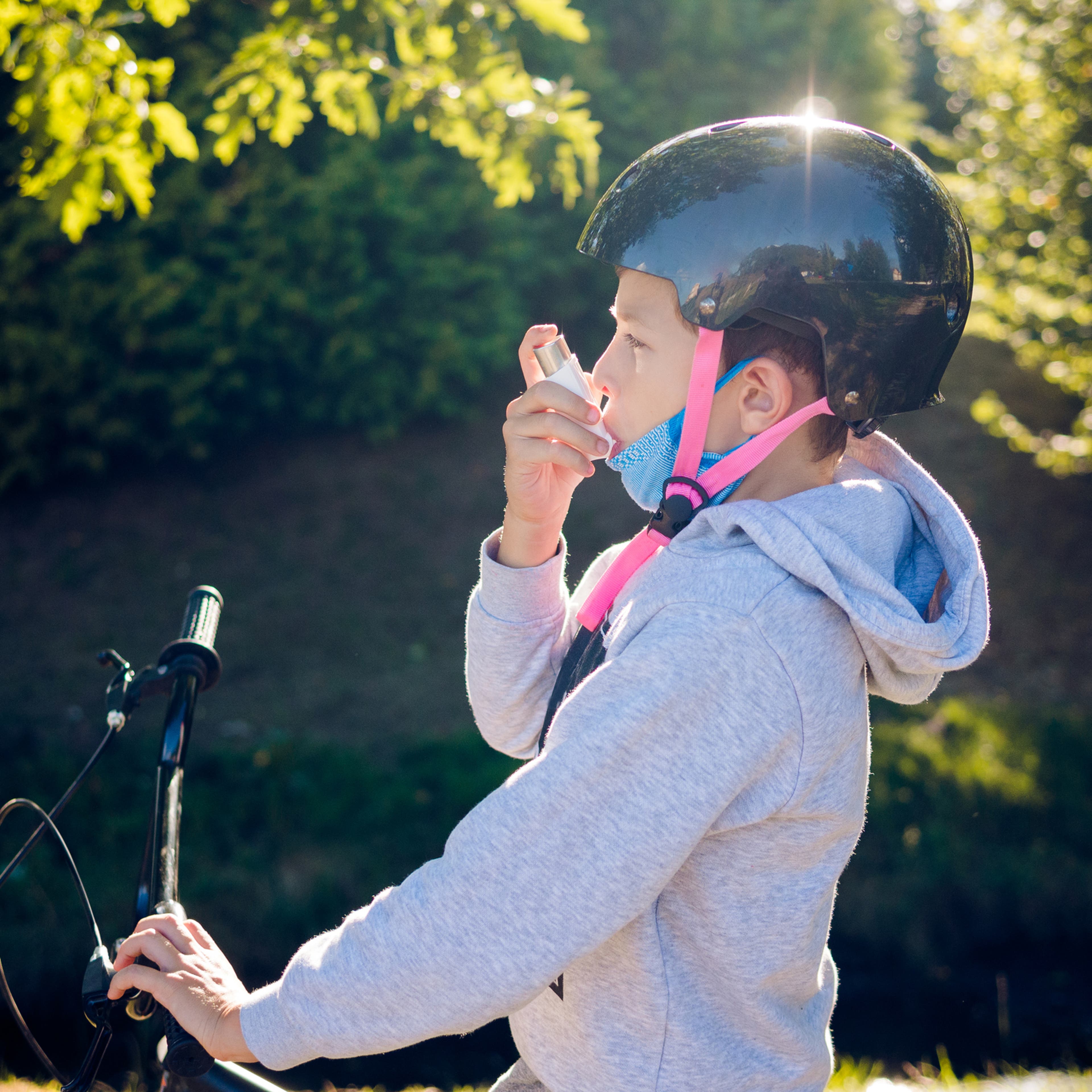Young boy using an inhalator outdoors