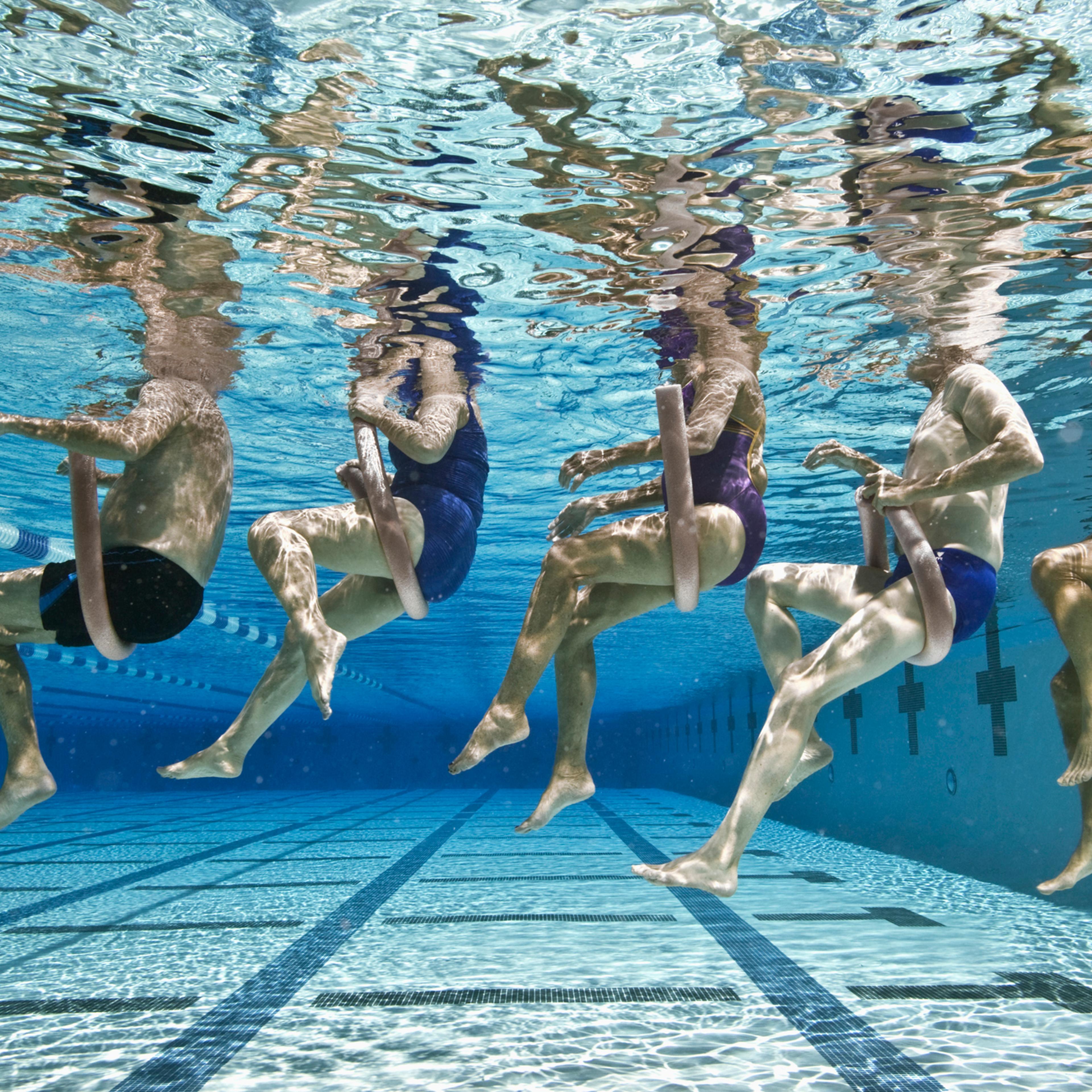 Five senior people swimming in a pool