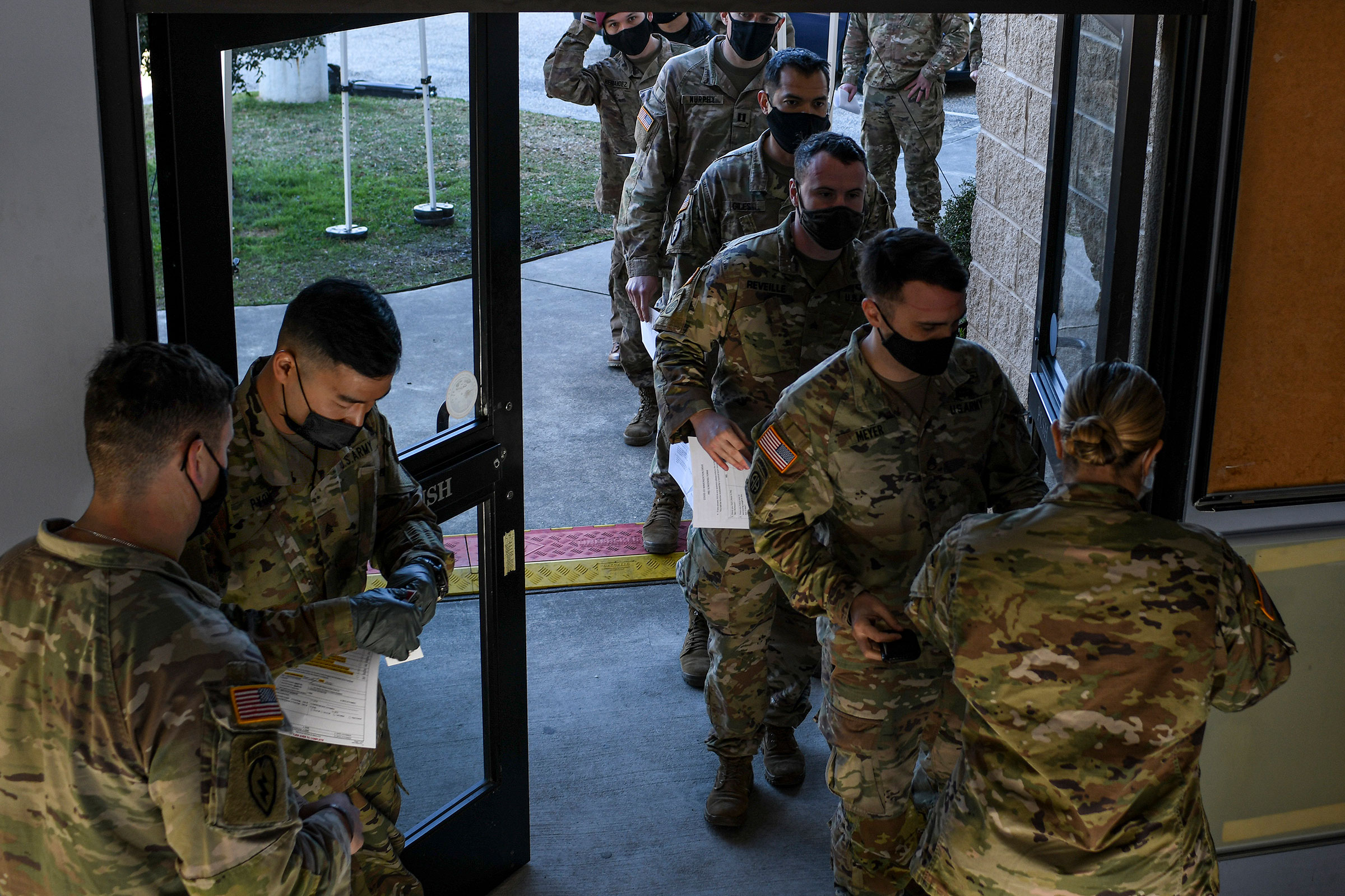 Soldiers line up for a medical screening before receiving the coronavirus vaccine at Fort Bragg in North Carolina, Feb. 24, 2021.   (Kenny Holston/The New York Times)