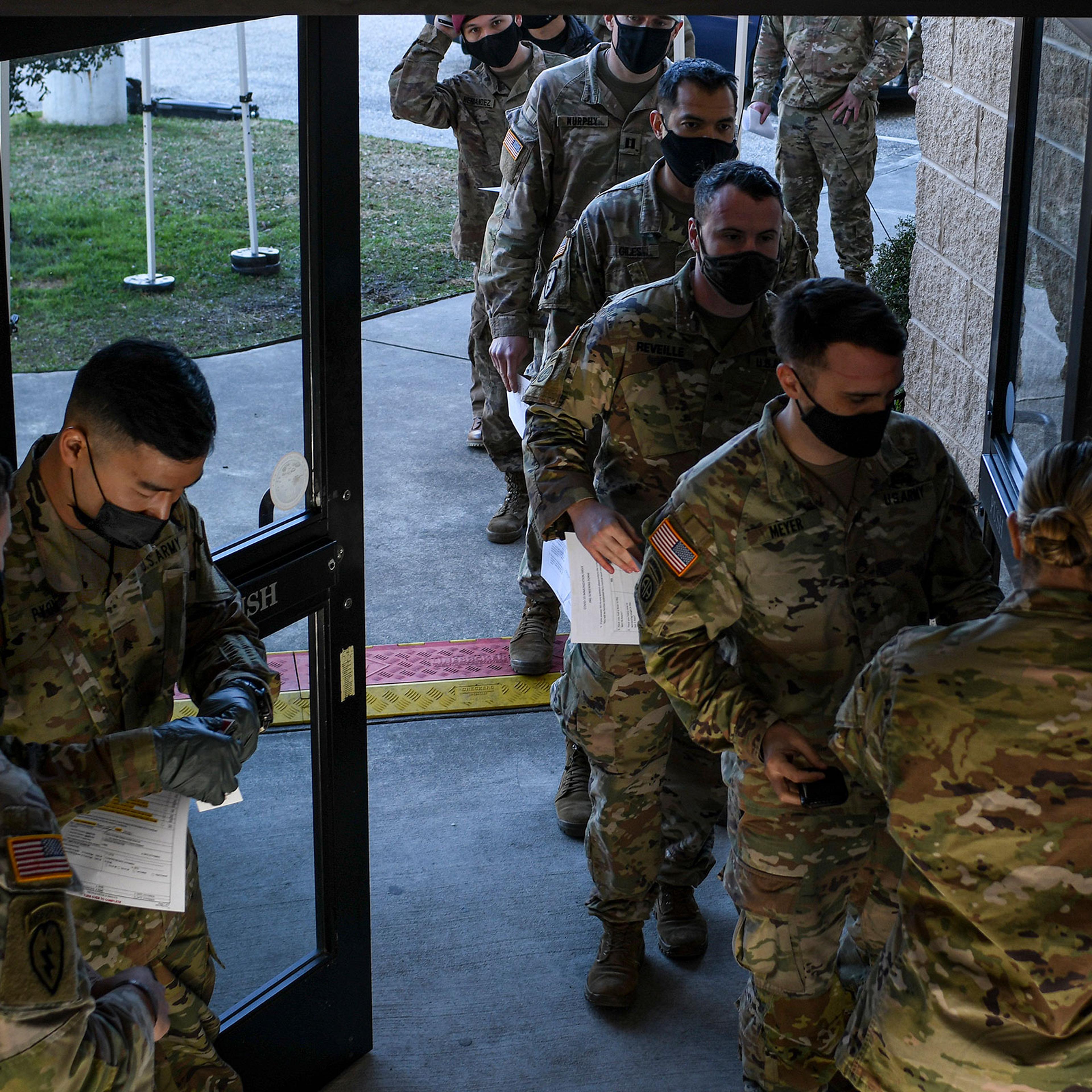 Soldiers line up for a medical screening before receiving the coronavirus vaccine at Fort Bragg in North Carolina, Feb. 24, 2021. (Kenny Holston/The New York Times)