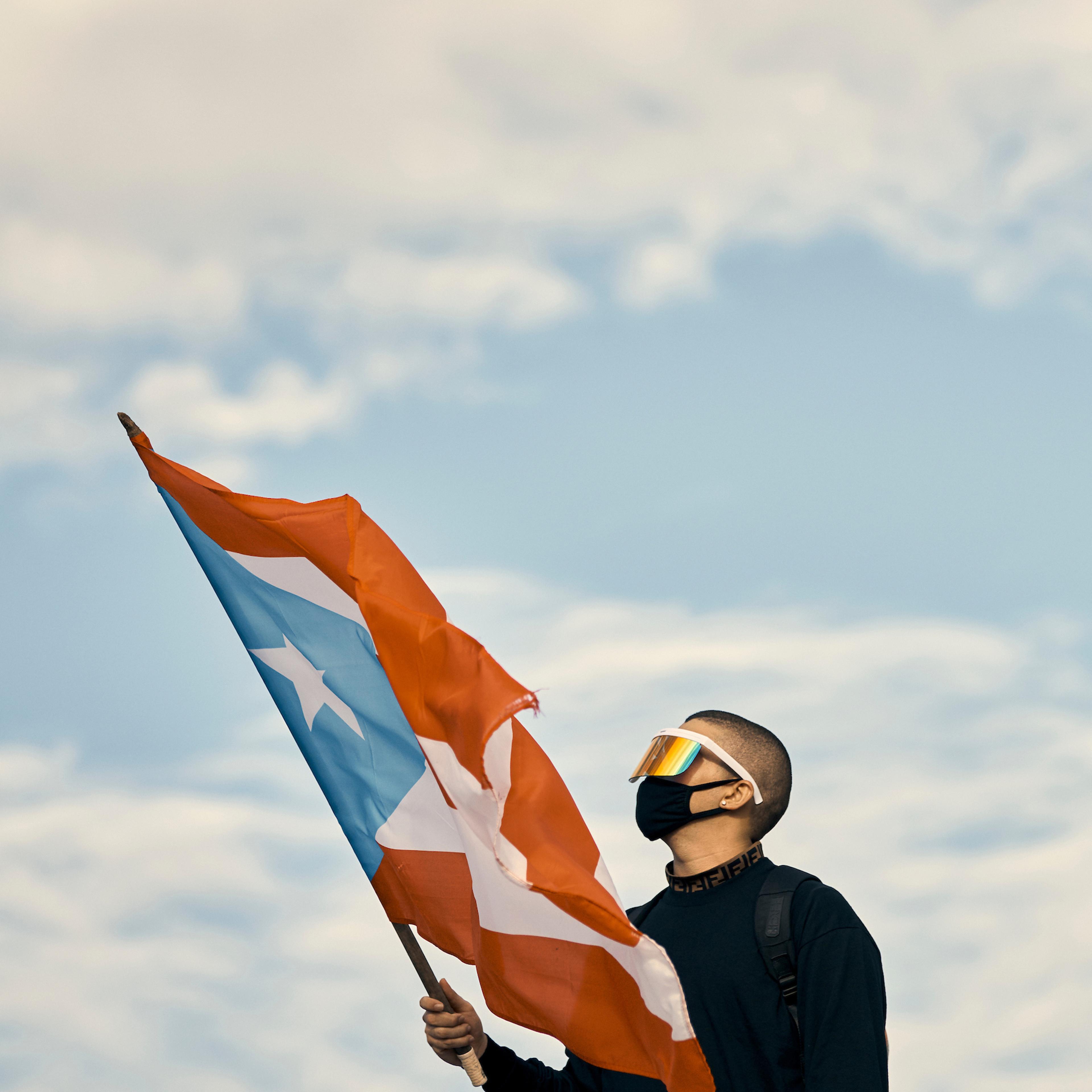 Bad Bunny waves a flag at the anti-Rosselló protest in San Juan, Puerto Rico, on July 17, 2019.
