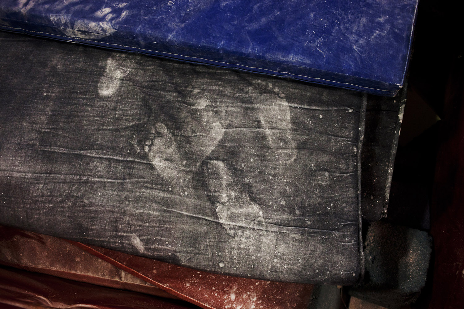 Chalky white footprints left behind on training gym mats.