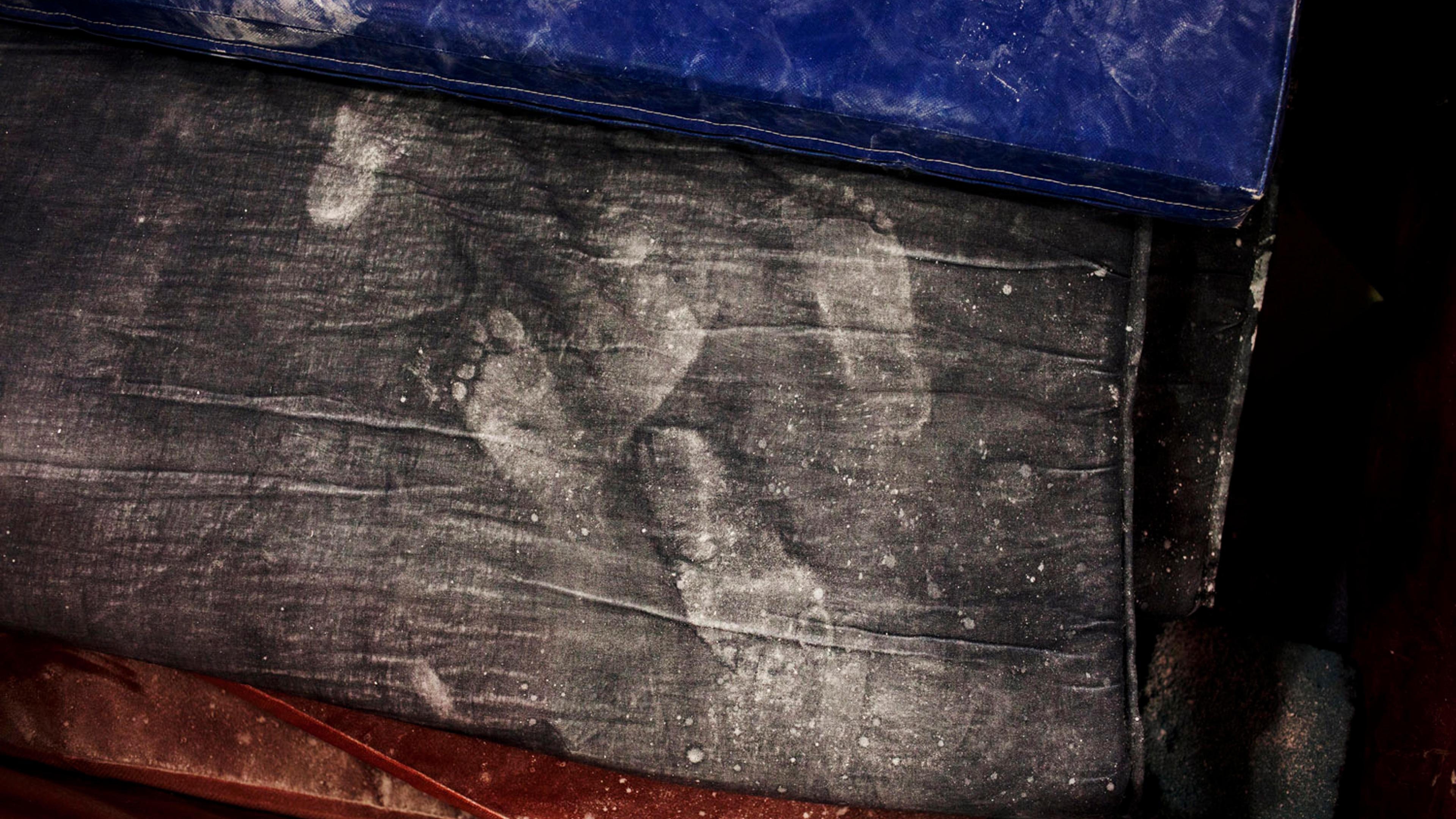 Chalky white footprints left behind on training gym mats.