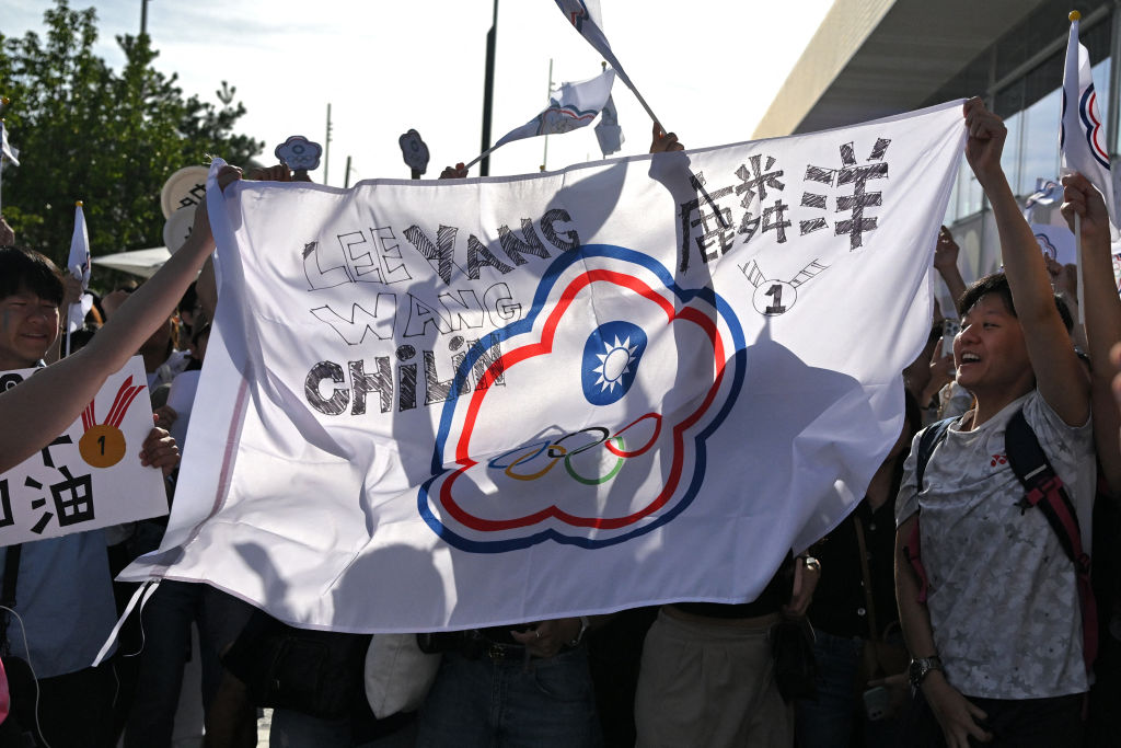 Supporters of Taiwan's Lee Yang and Wang Chi-lin celebrate with the Chinese Taipei Olympic flag outside the Porte de la Chapelle Arena in Paris on Aug. 4, 2024, after they won the gold medals in men's doubles badminton during the Paris 2024 Olympic Games