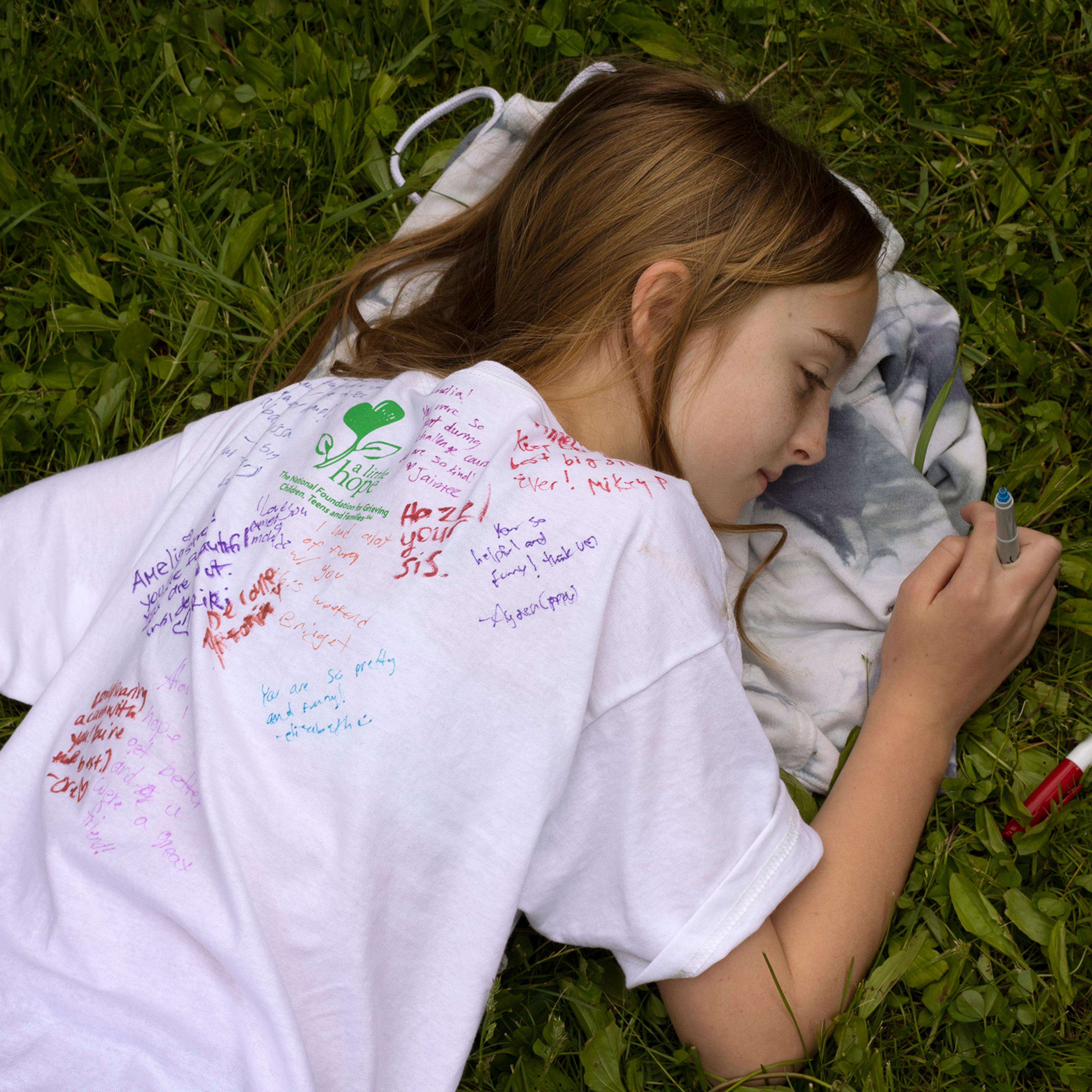 On the last day of Comfort Zone Camp, kids sign one another's shirts. Pictured here is camper Amelia Smith.