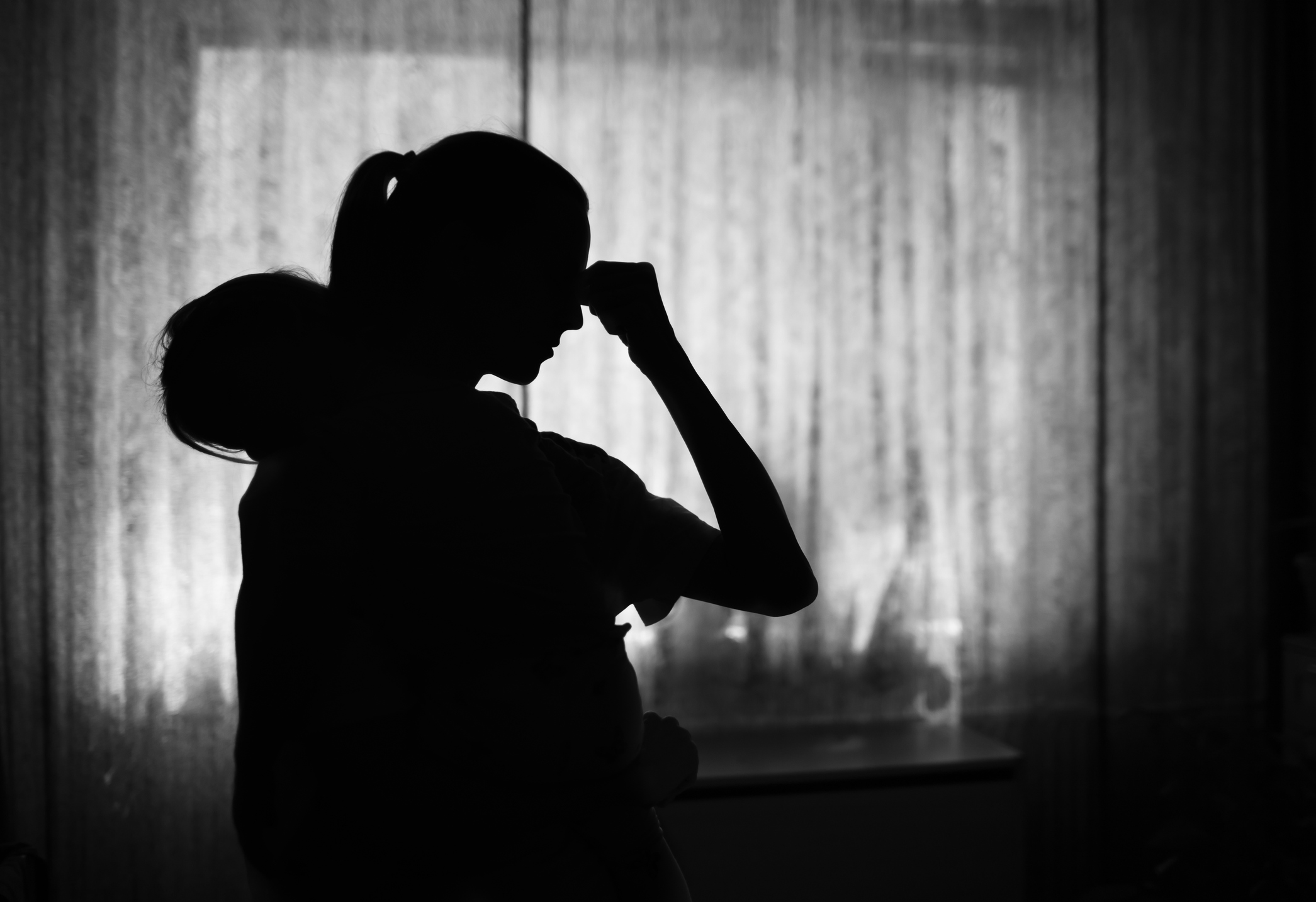 Exausted tired mother at home taking care of baby