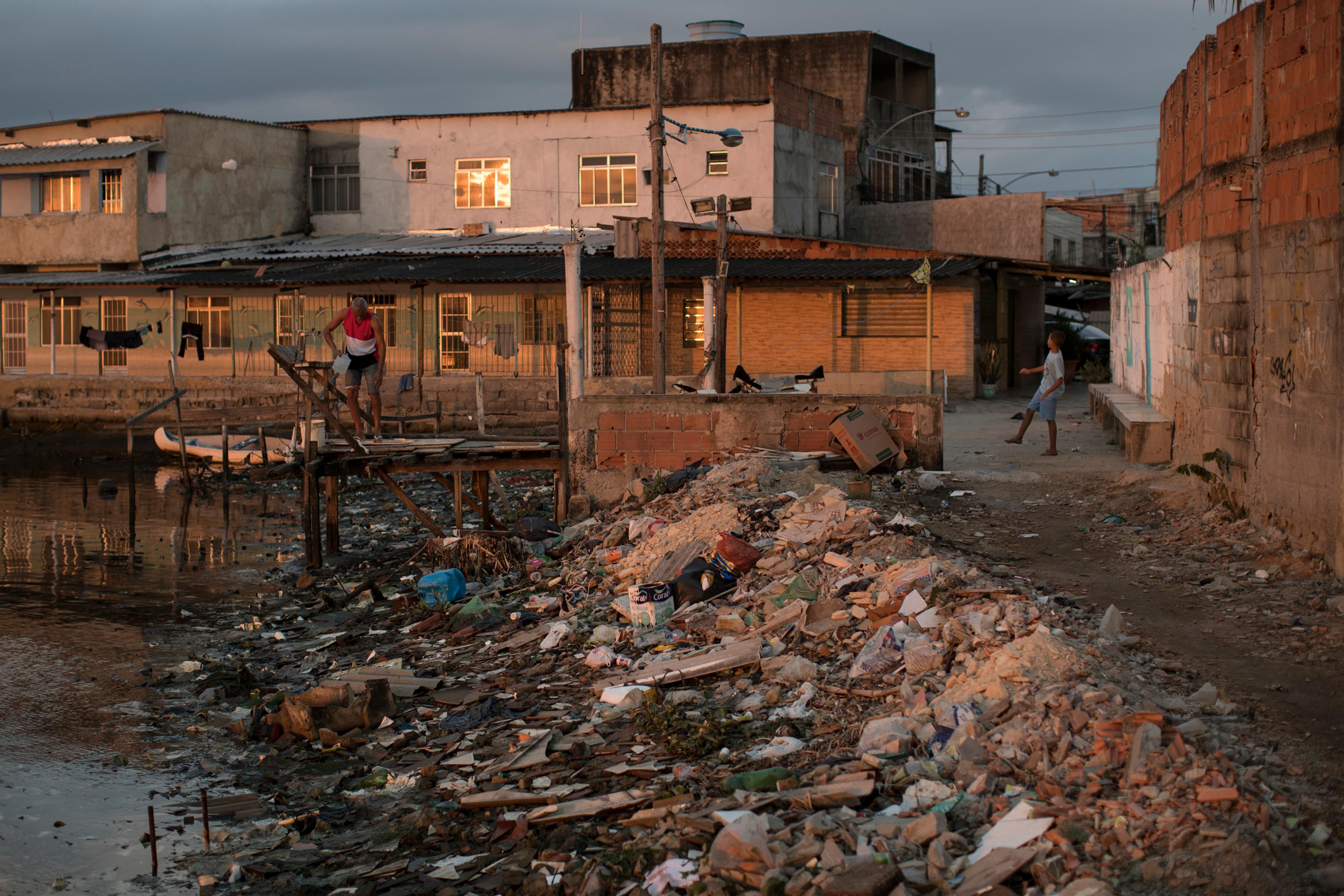 Houses sit next to a heavily polluted shore in Guanabara bay in Rio de Janeiro on July 30, 2016.
