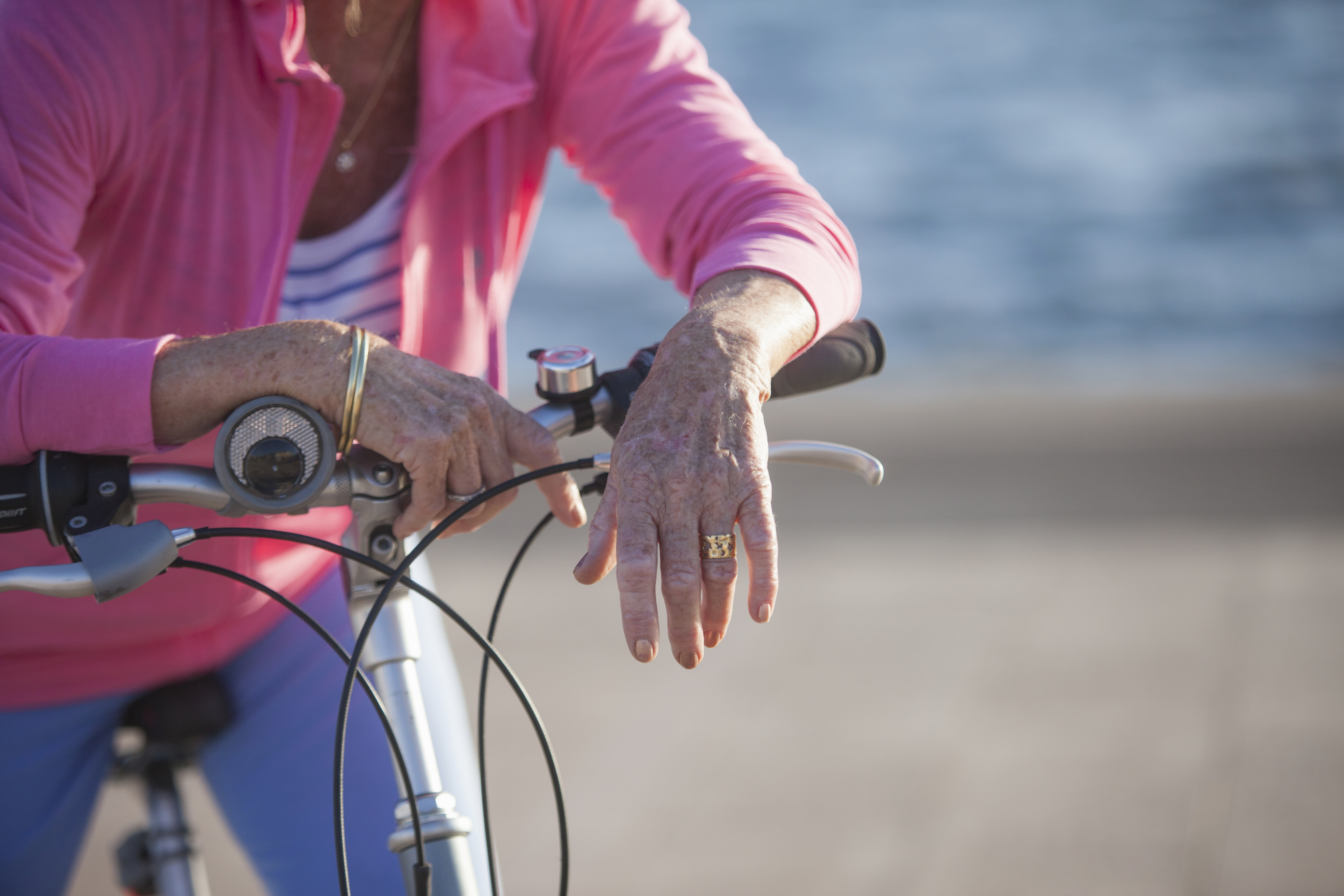 Senior woman on bicycle by beach