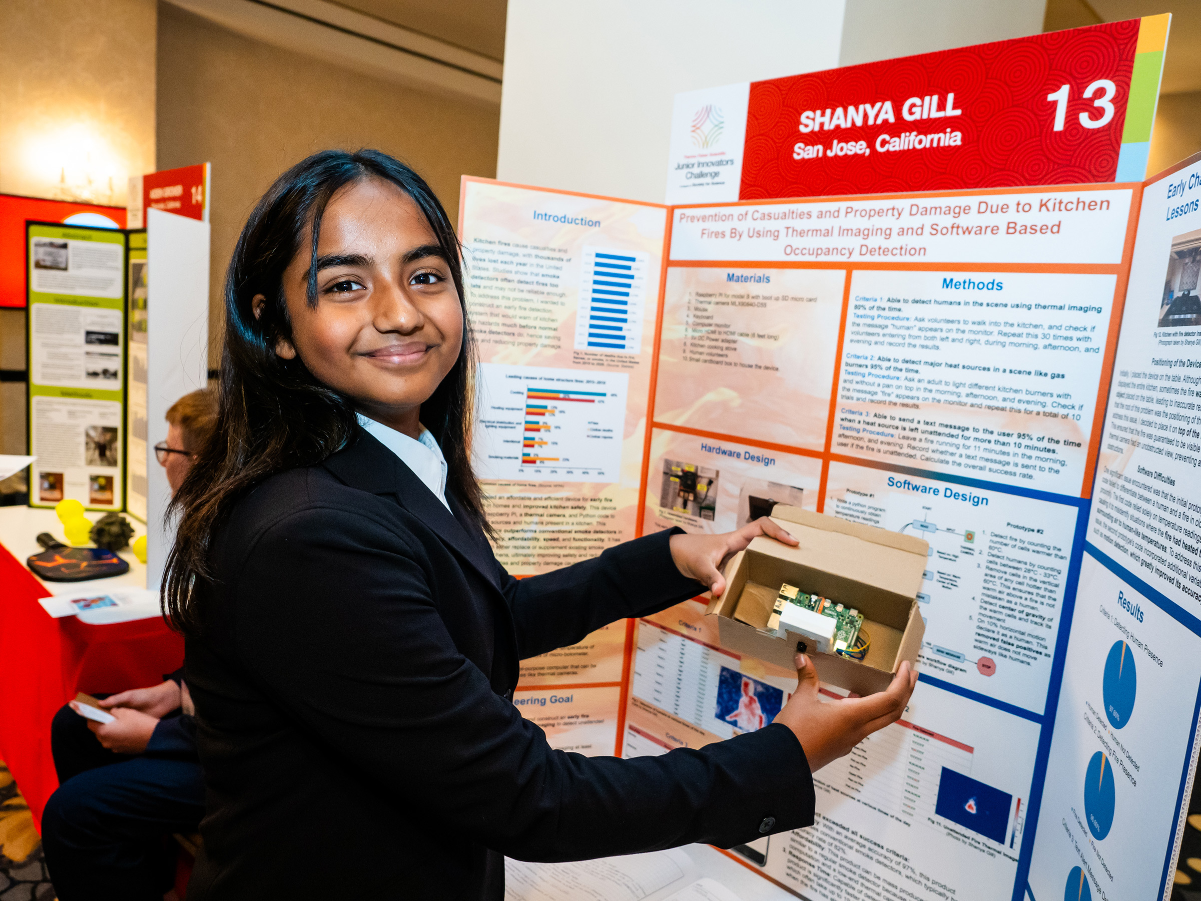 Shanya Gill proudly presents a prototype and plans for her early fire-detection device
