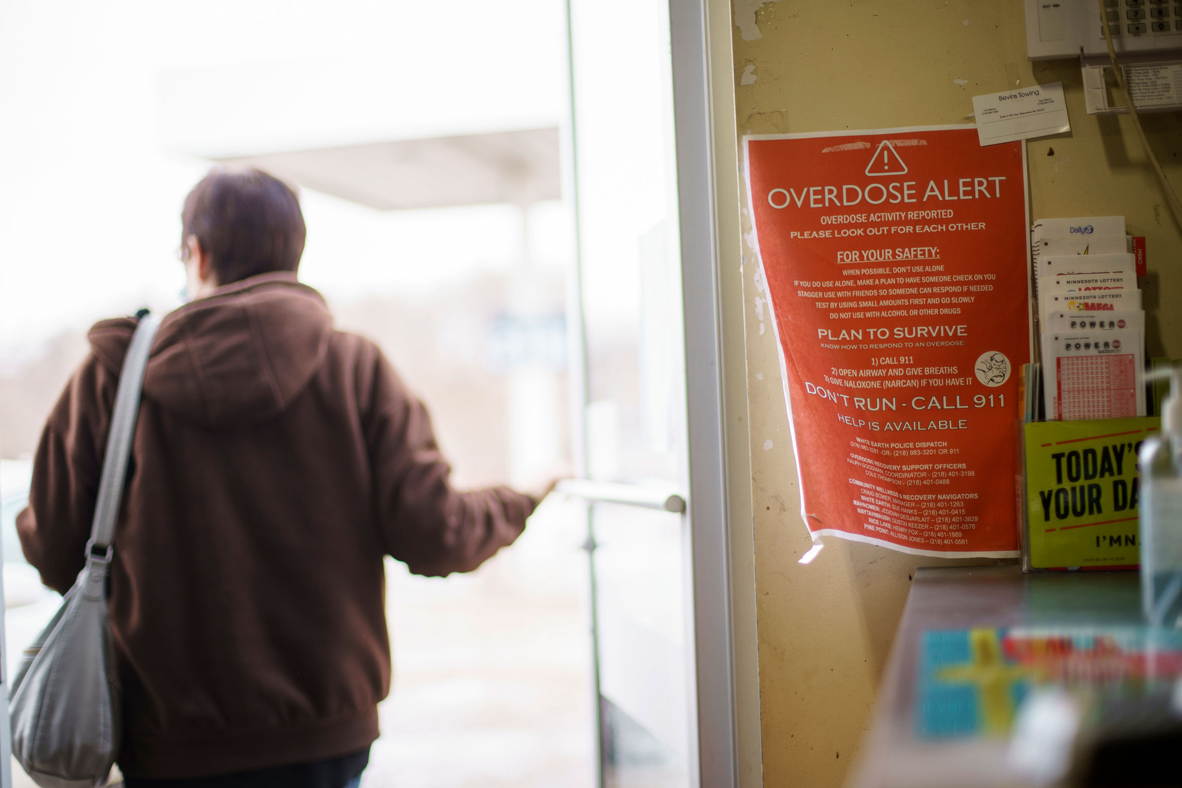 A sign calling attention to drug overdoses is posted to the door of a gas station