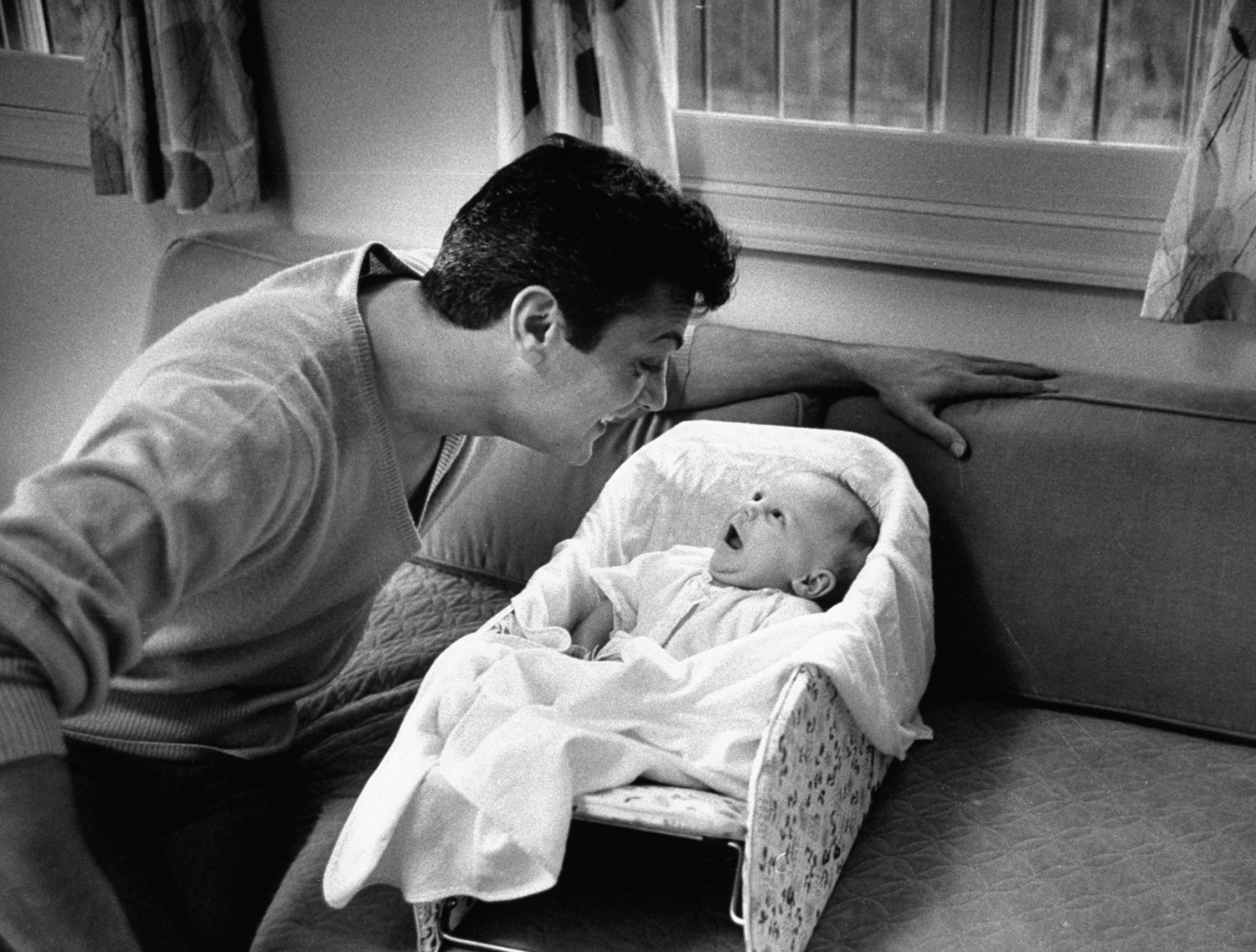 Tony Curtis smiles at his daughter, Jamie Lee, in 1959.