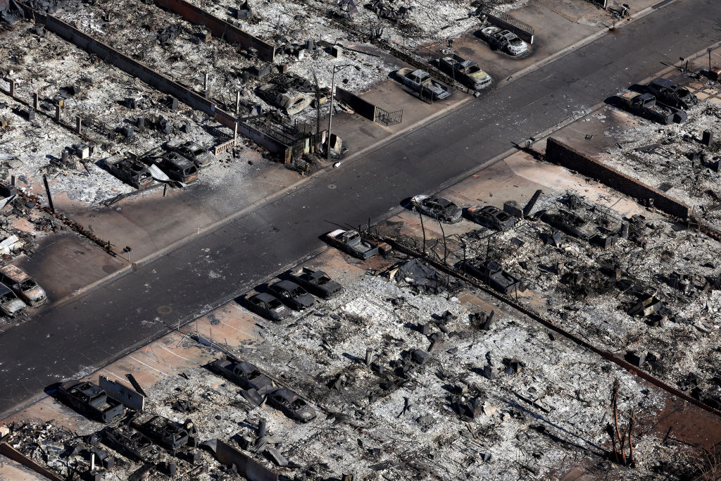 Burned cars sit in front of homes destroyed by a wildfire on August 11, 2023 in Lahaina, Hawaii. Dozens of people were killed and thousands were displaced.