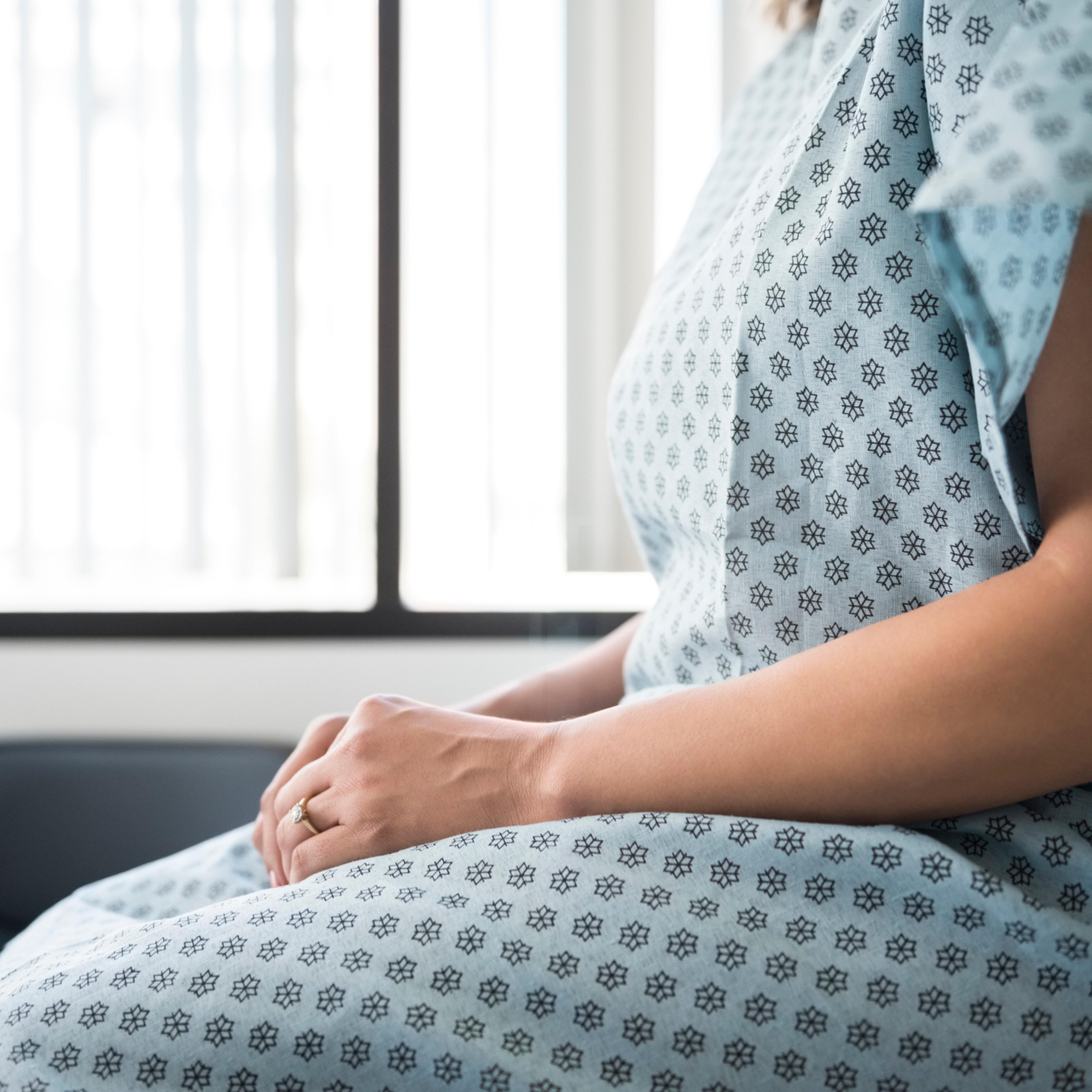 Midsection of female patient waiting in hospital exam room