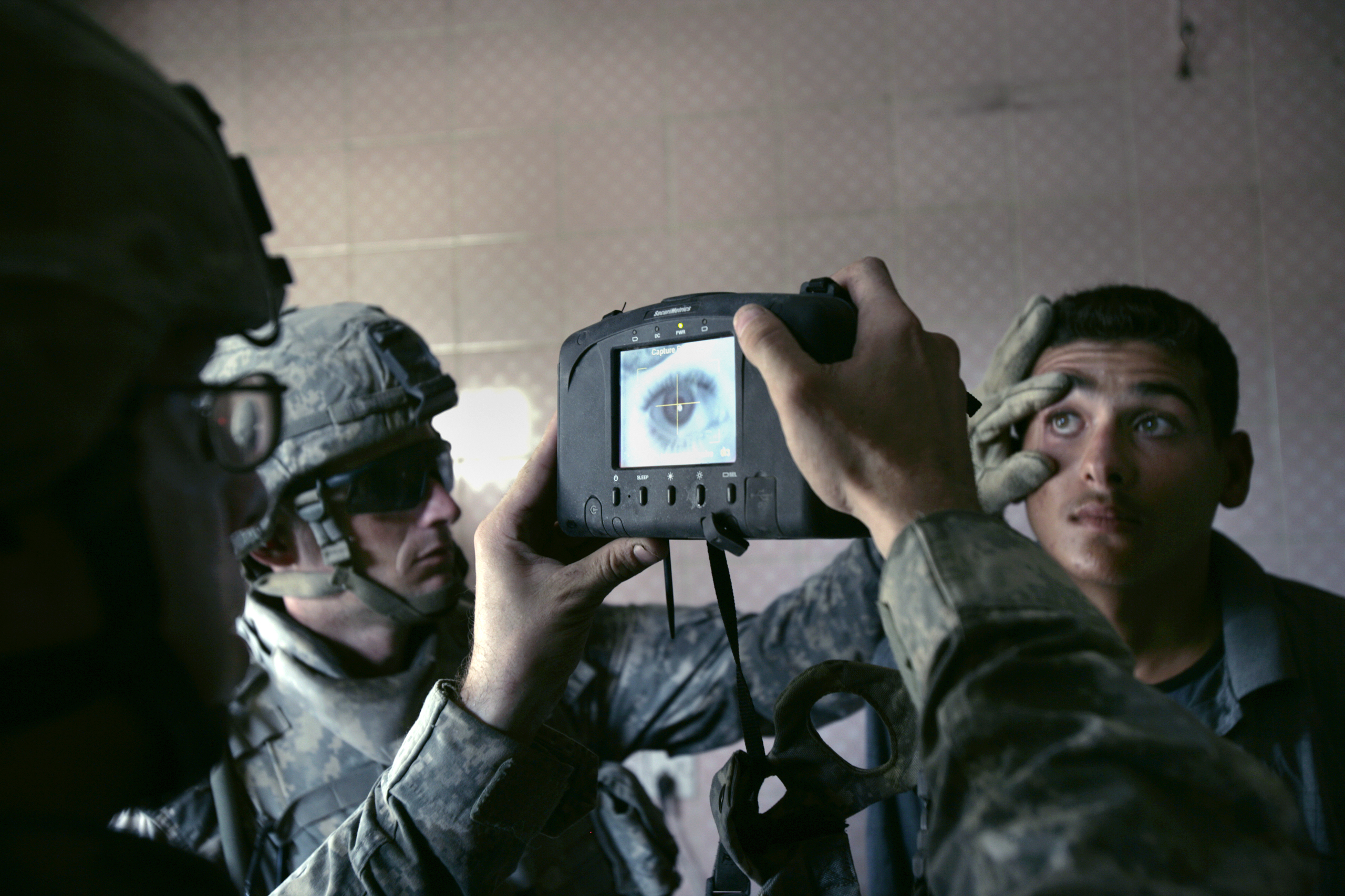 A U.S. Army soldier with 1st Battalion, 5th Cavalry Regiment, 2nd Brigade, 1st Cavalry Division scans an Iraqi man's eye during a census operation in the Amariyah neighborhood of west Baghdad, Aug. 5, 2007. The American soldiers try to take the name, add