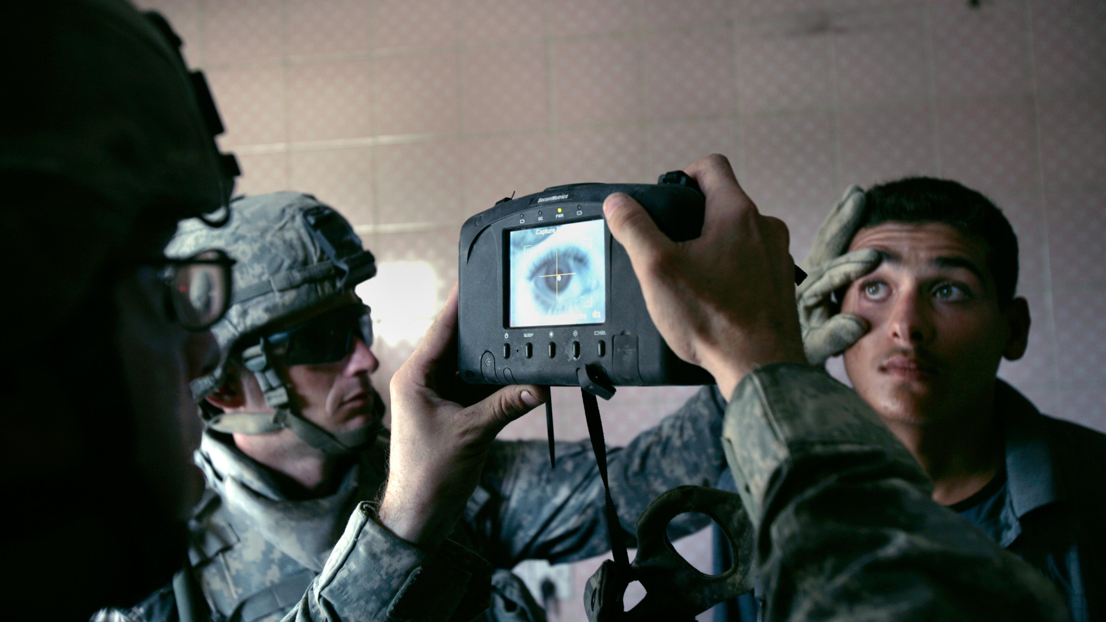 A U.S. Army soldier with 1st Battalion, 5th Cavalry Regiment, 2nd Brigade, 1st Cavalry Division scans an Iraqi man's eye during a census operation in the Amariyah neighborhood of west Baghdad, Aug. 5, 2007. The American soldiers try to take the name, add