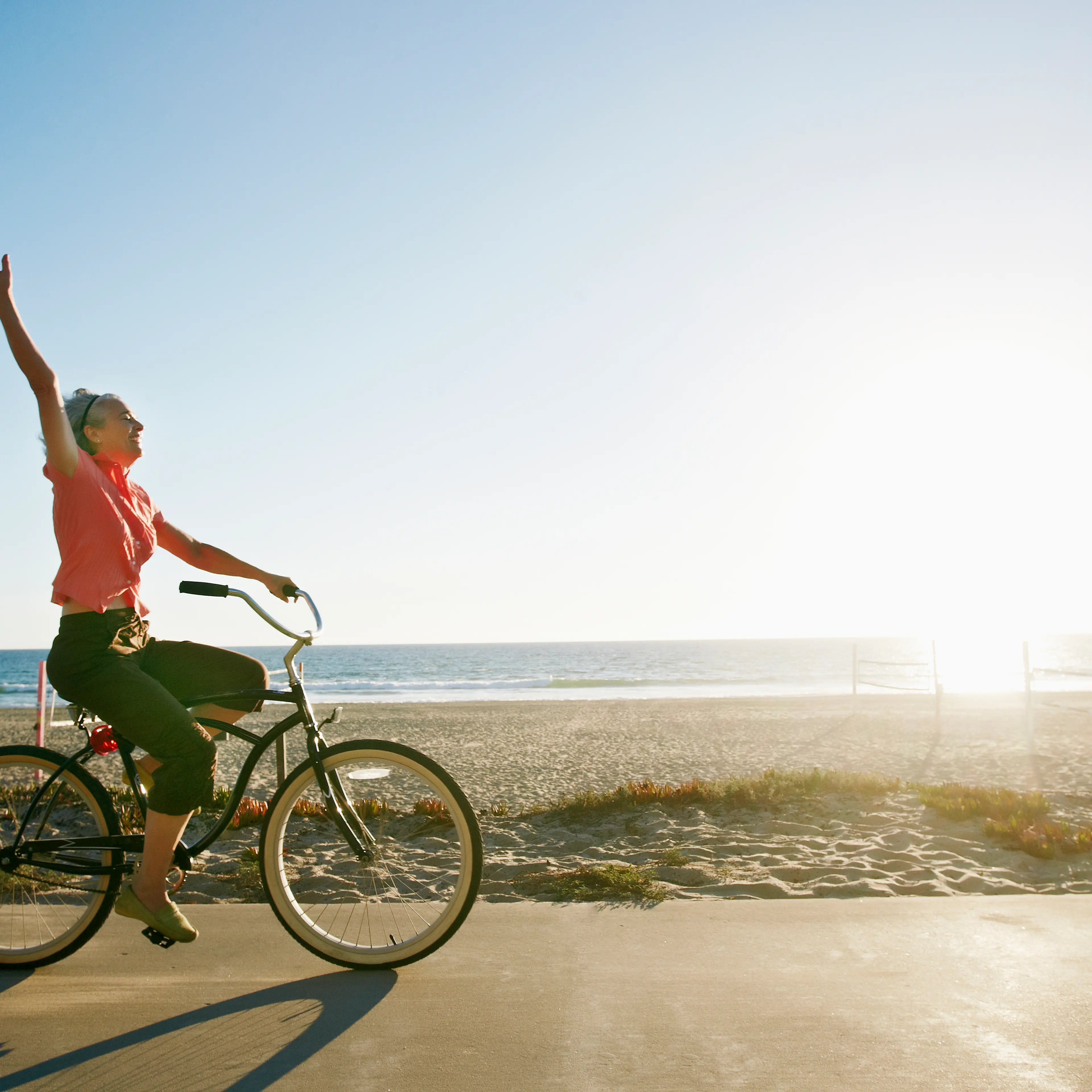 Caucasian woman riding bicycle near beach