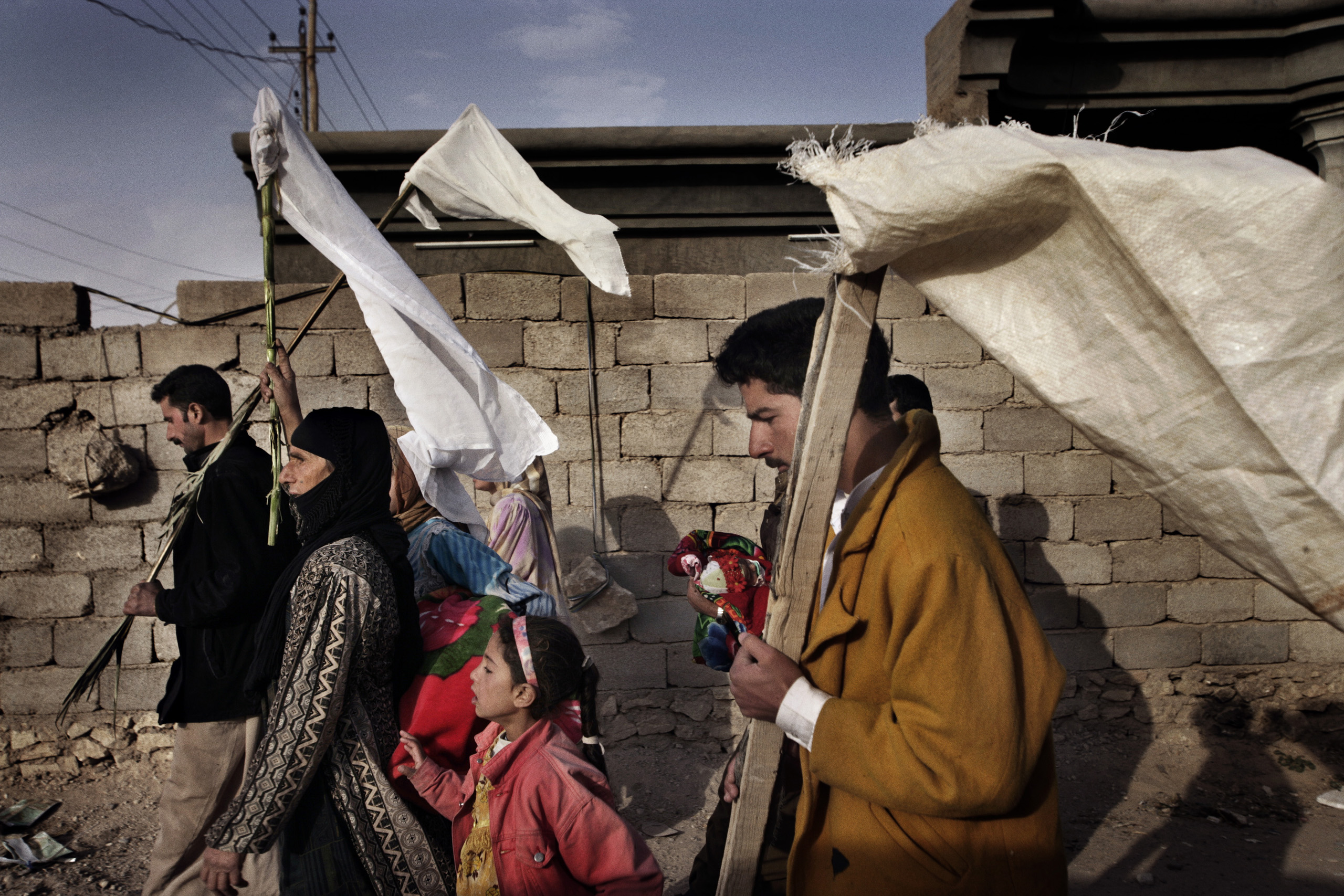 Iraqi civilians wave white flags for protection while fleeing the city of Husaybah during Operation Steel Curtain, a ​joint American-Iraqi offensive to stop the flow of insurgents crossing the Iraqi- Syrian border, Nov. 7, 2005