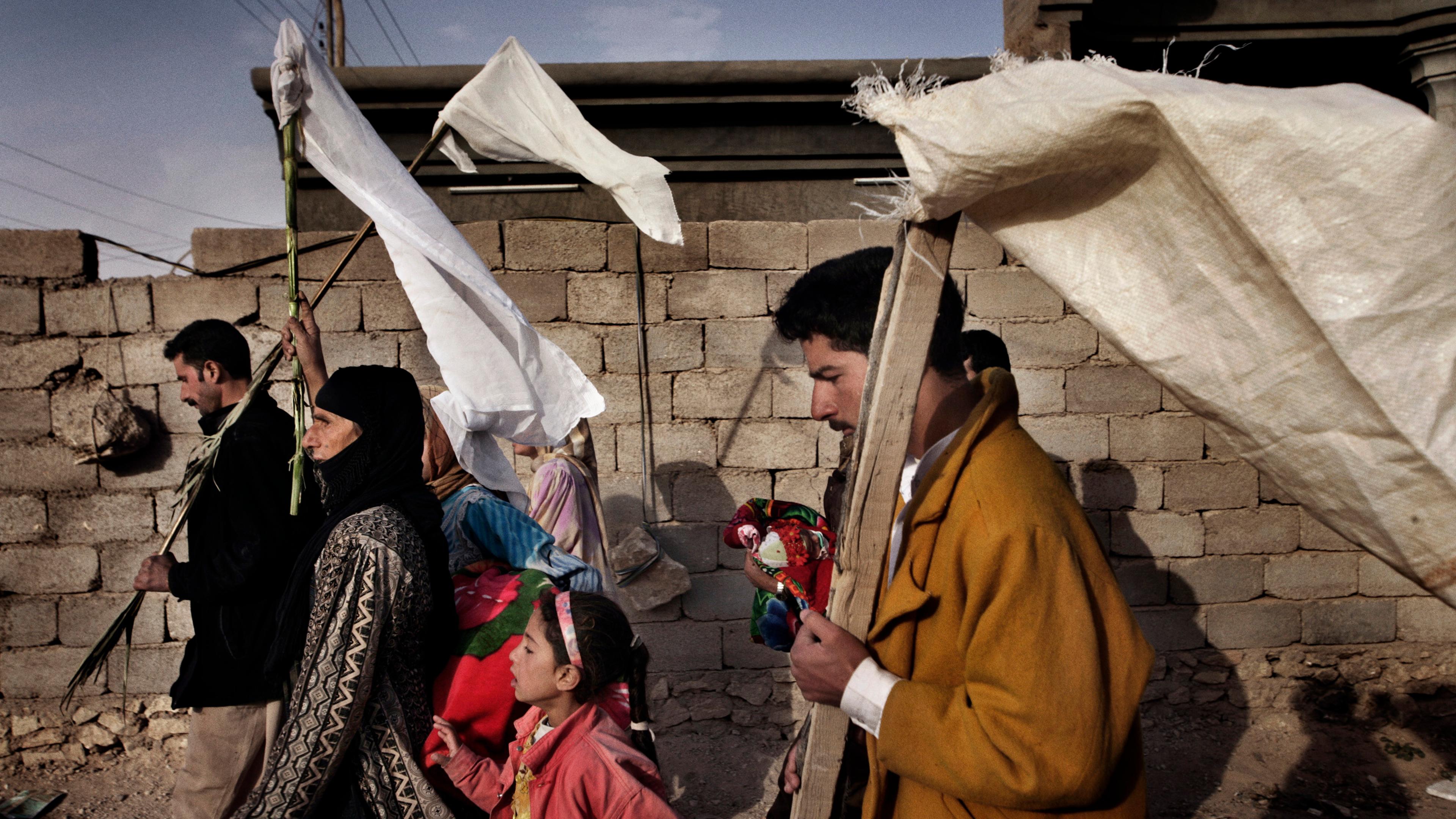 Iraqi civilians wave white flags for protection while fleeing the city of Husaybah during Operation Steel Curtain, a joint American-Iraqi offensive to stop the flow of insurgents crossing the Iraqi- Syrian border, Nov. 7, 2005