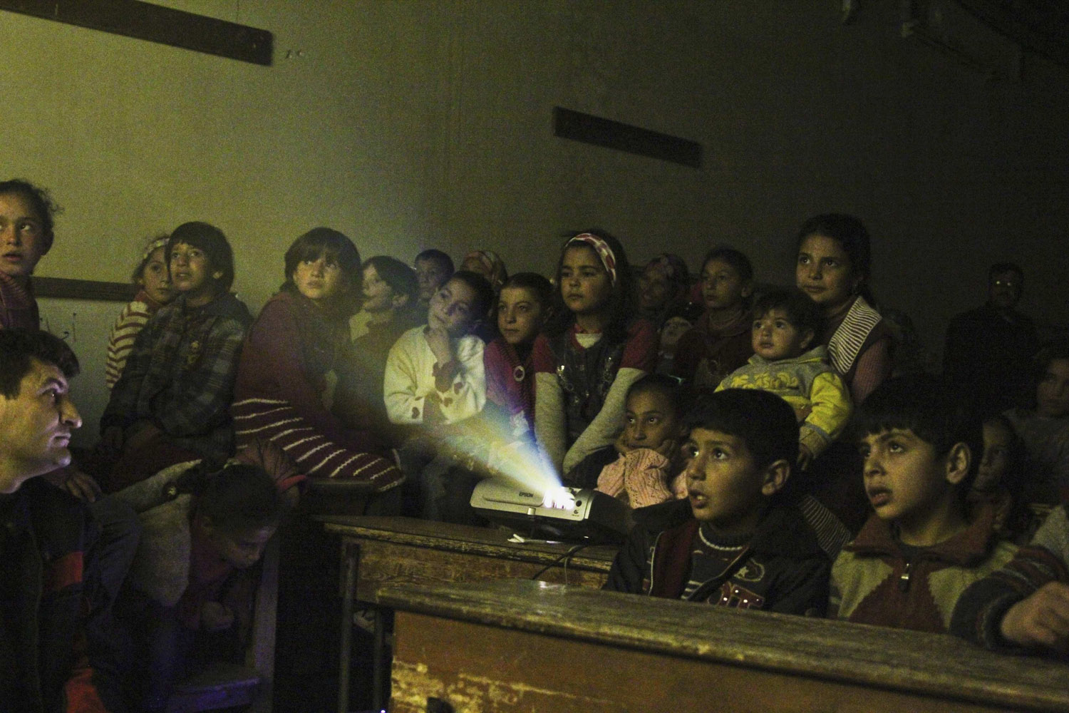 Jan. 16, 2013. Internally displaced children watch cartoons in a classroom of a school in Kafranbel in Idlib province, Syria.