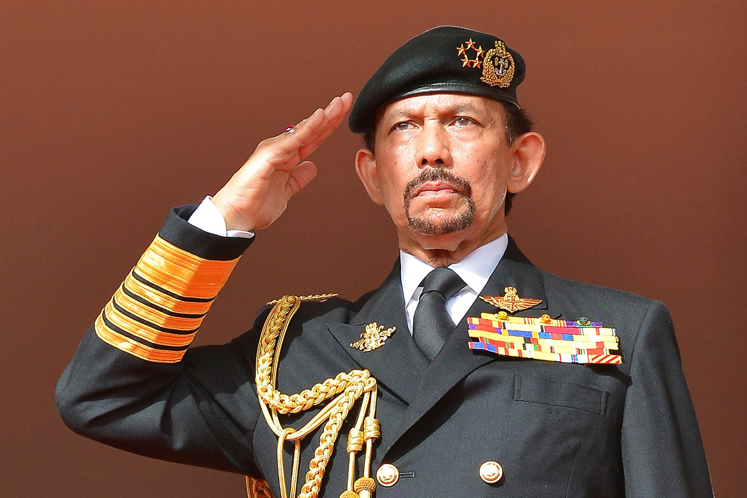 Brunei's Sultan Hassanal Bolkiah salutes as the national anthem is played during celebrations for Brunei's 30th National Day, in Bandar Seri Begawan on Feb. 23, 2014.