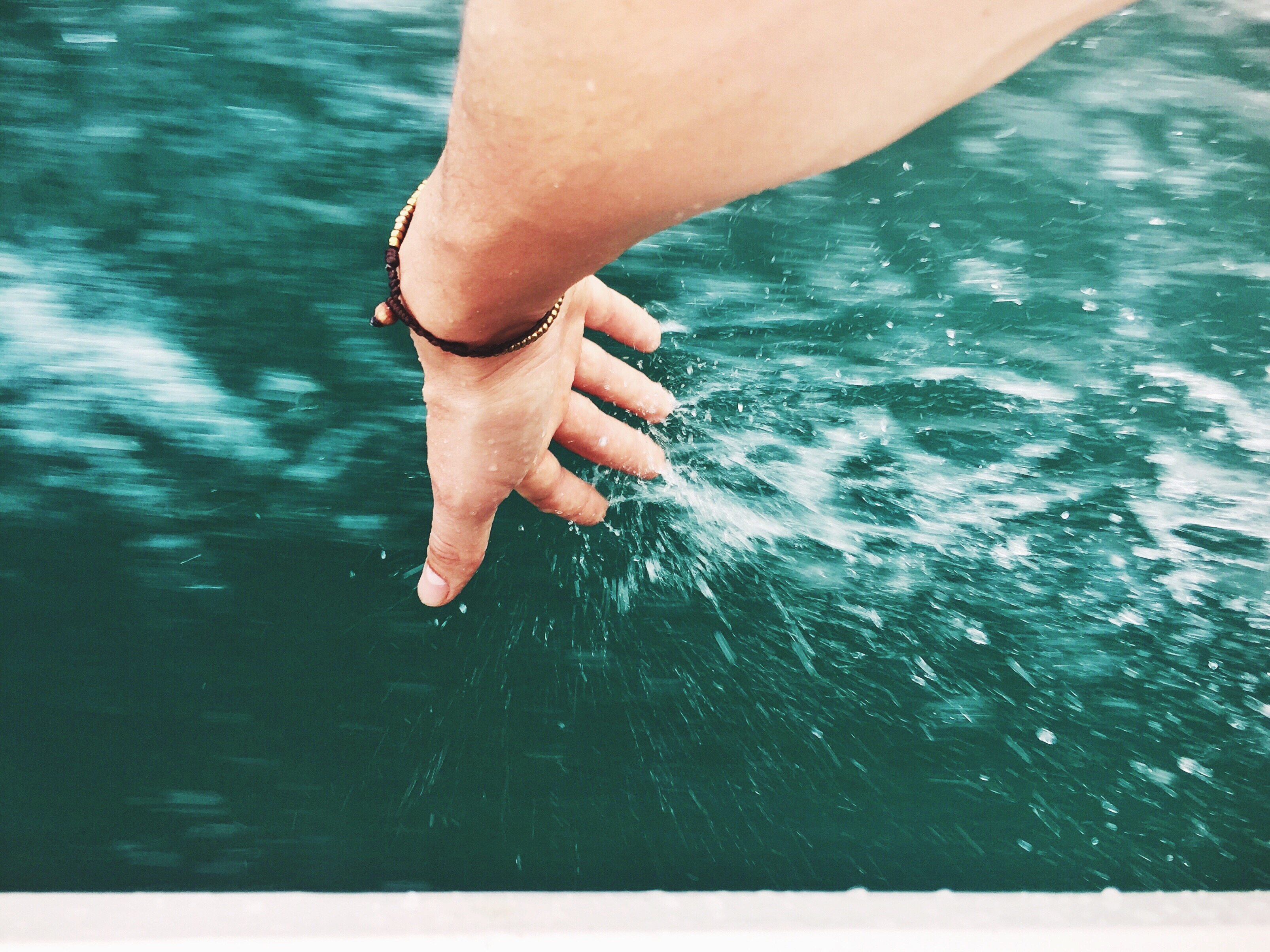 Woman Touching Water While Sitting In Boat