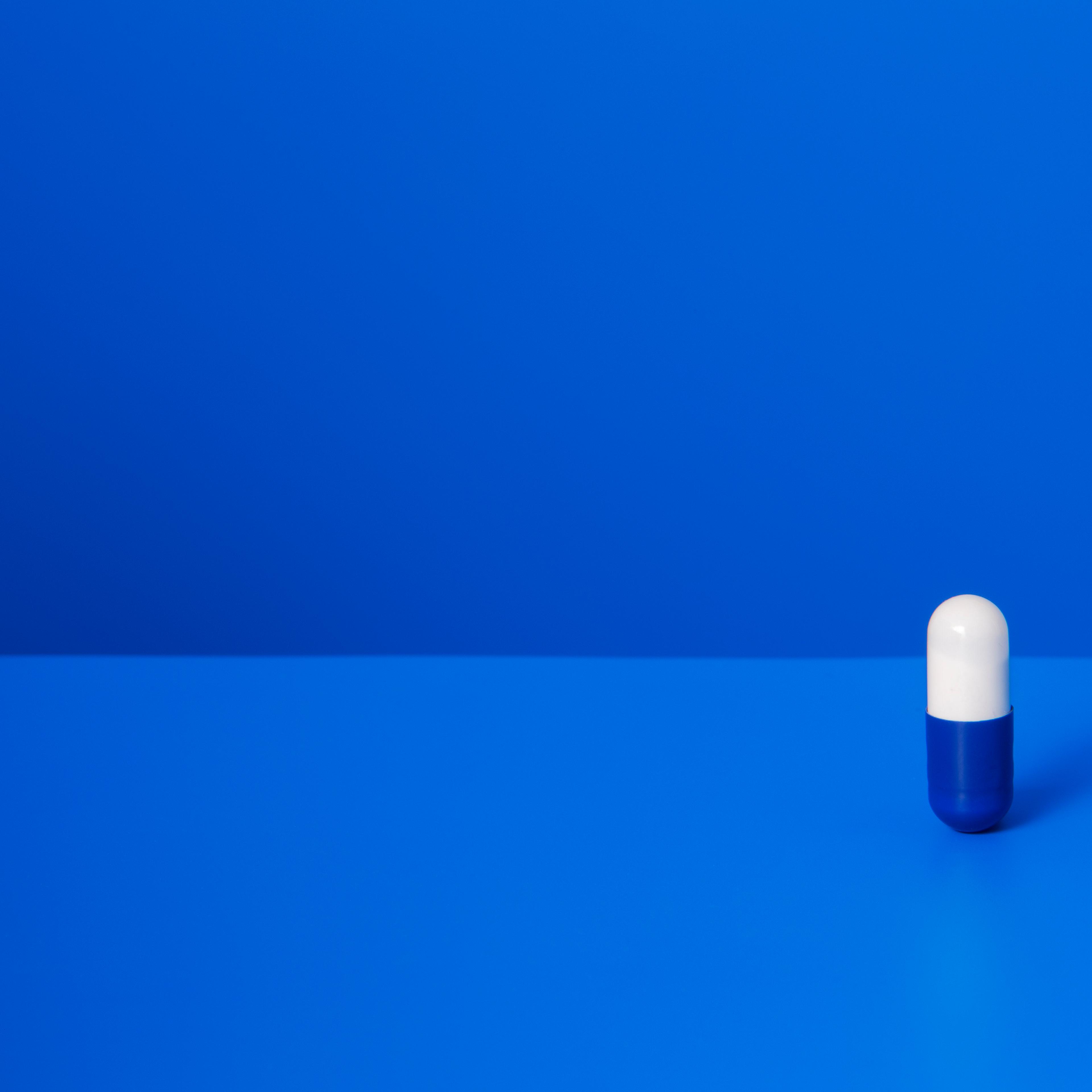 Prescription pill standing upright on blue counter TIME health
