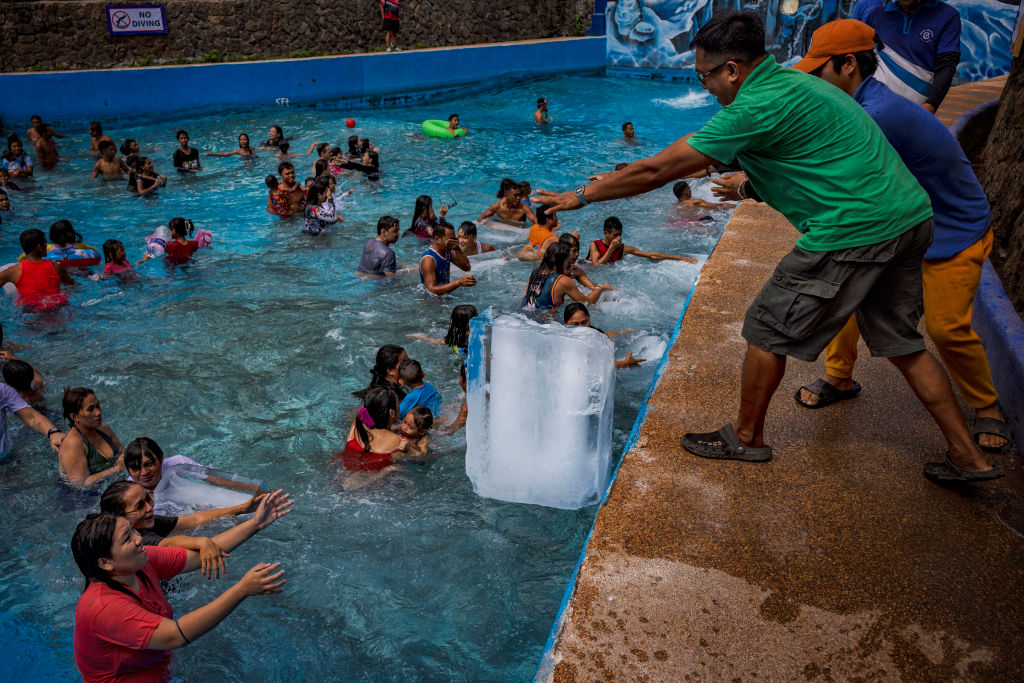 Workers dump blocks of ice at a pool amid extreme heat at the Hidden Sanctuary Resort on May 4, 2024 in Marilao, Bulacan province, Philippines.