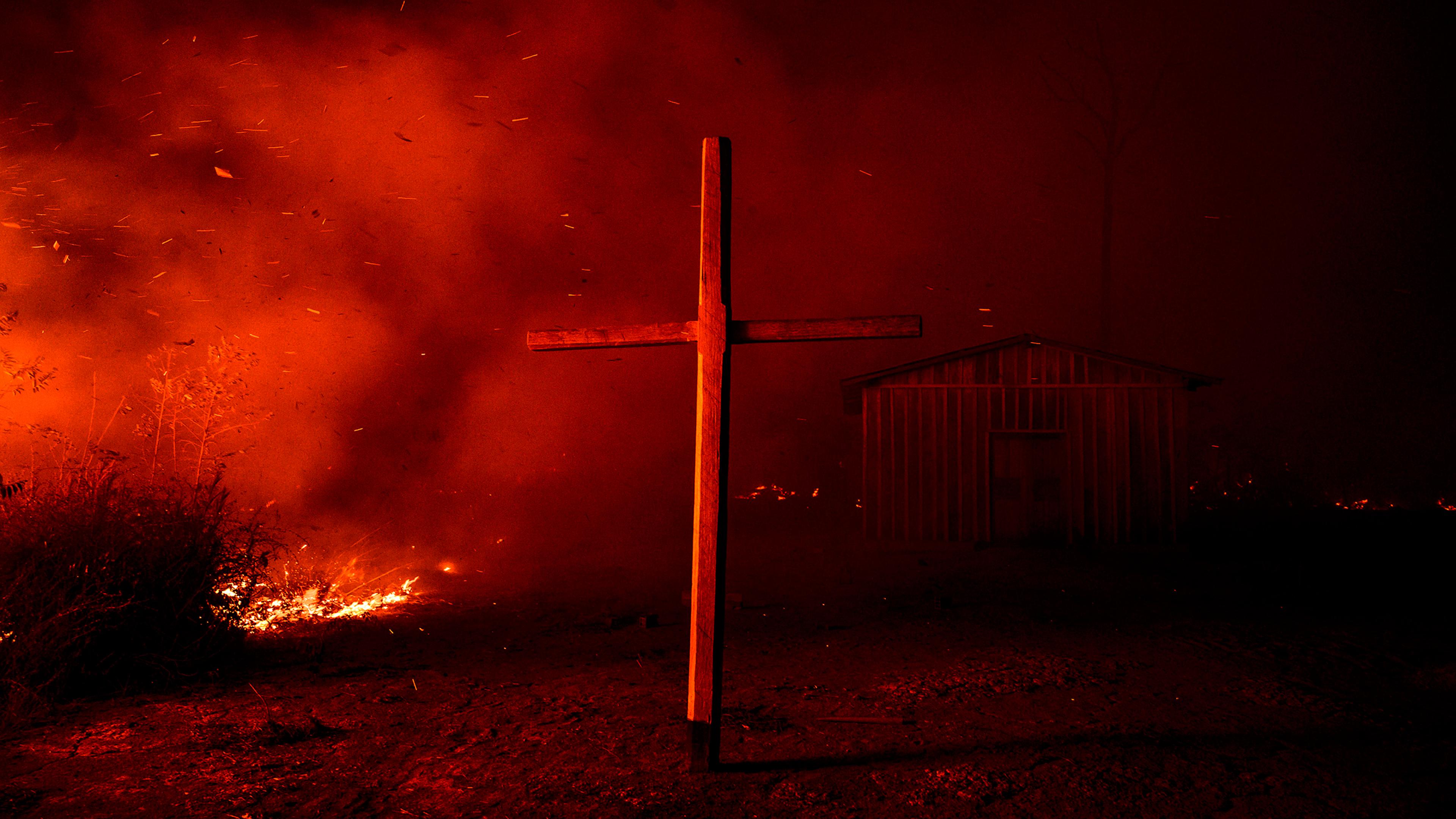 A church is enveloped in smoke from nearby flames in the region of Vila Nova Samuel, near the Jacundá National Forest, on Aug. 27.
