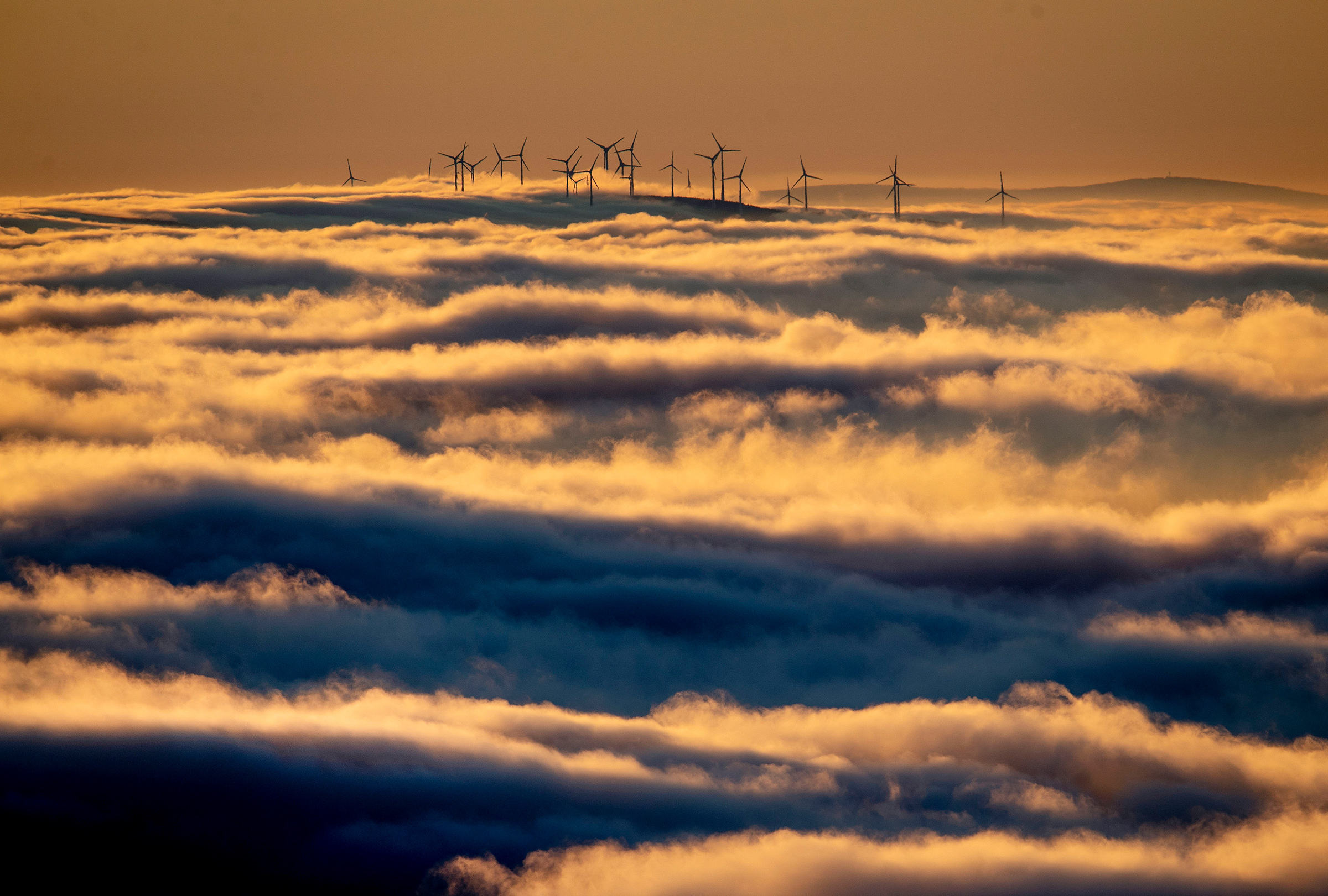 Wind turbines on a hill are surrounded by fog and clouds near Frankfurt in Jan. 6, 2020.