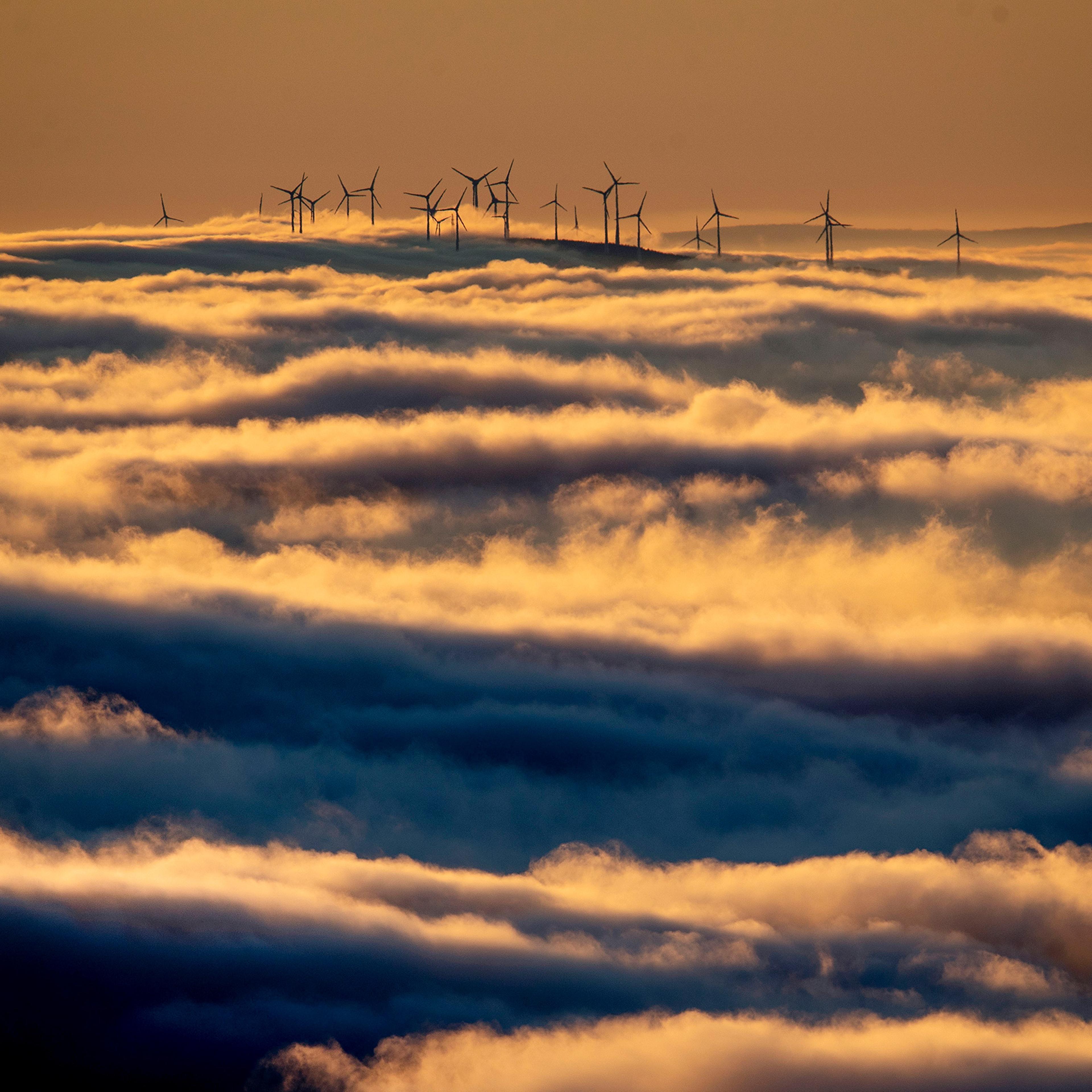 Wind turbines on a hill are surrounded by fog and clouds near Frankfurt in Jan. 6, 2020.