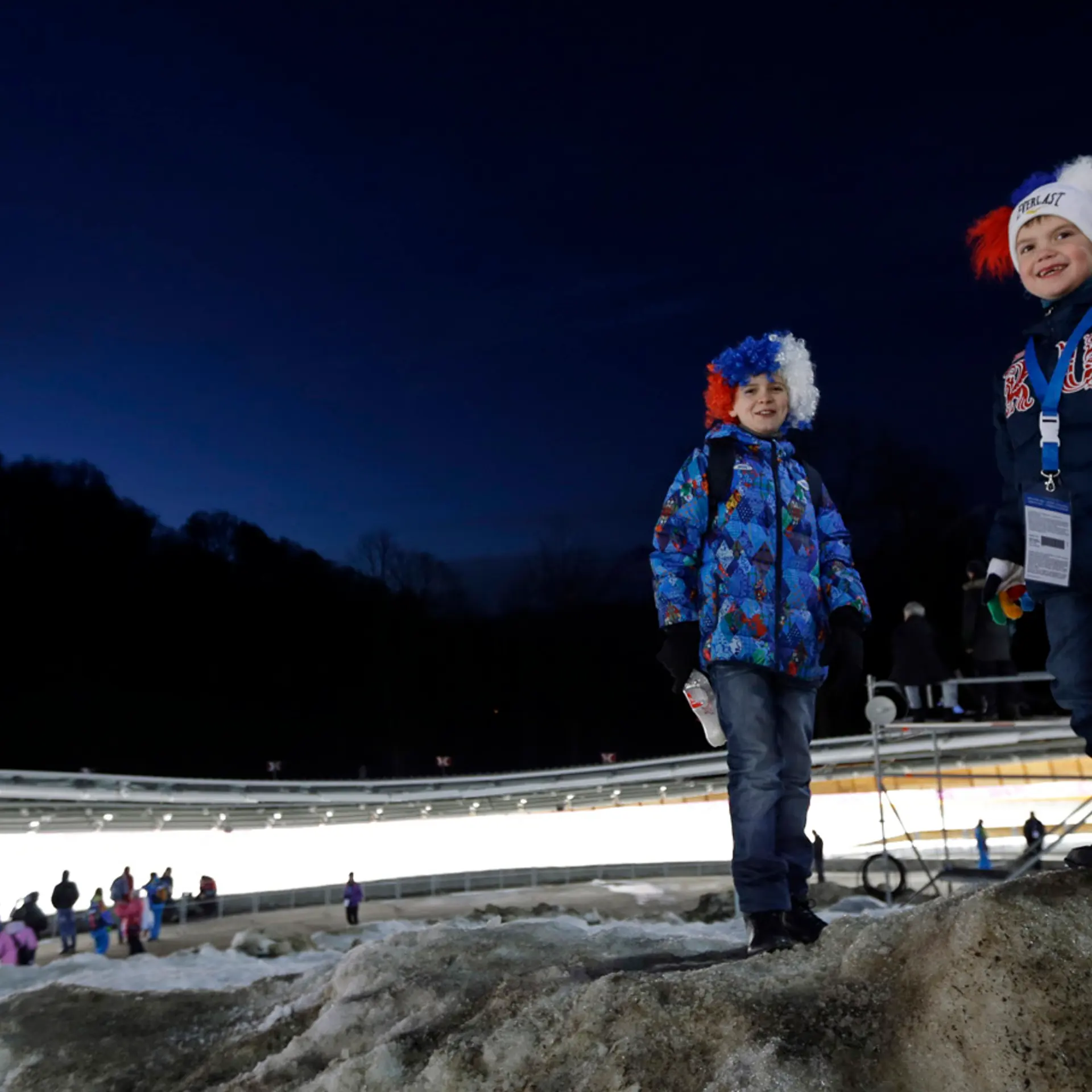 Children wait for the start of the final run during the men's doubles luge at the 2014 Winter Olympics, on Feb. 12, 2014, in Krasnaya Polyana, Russia.