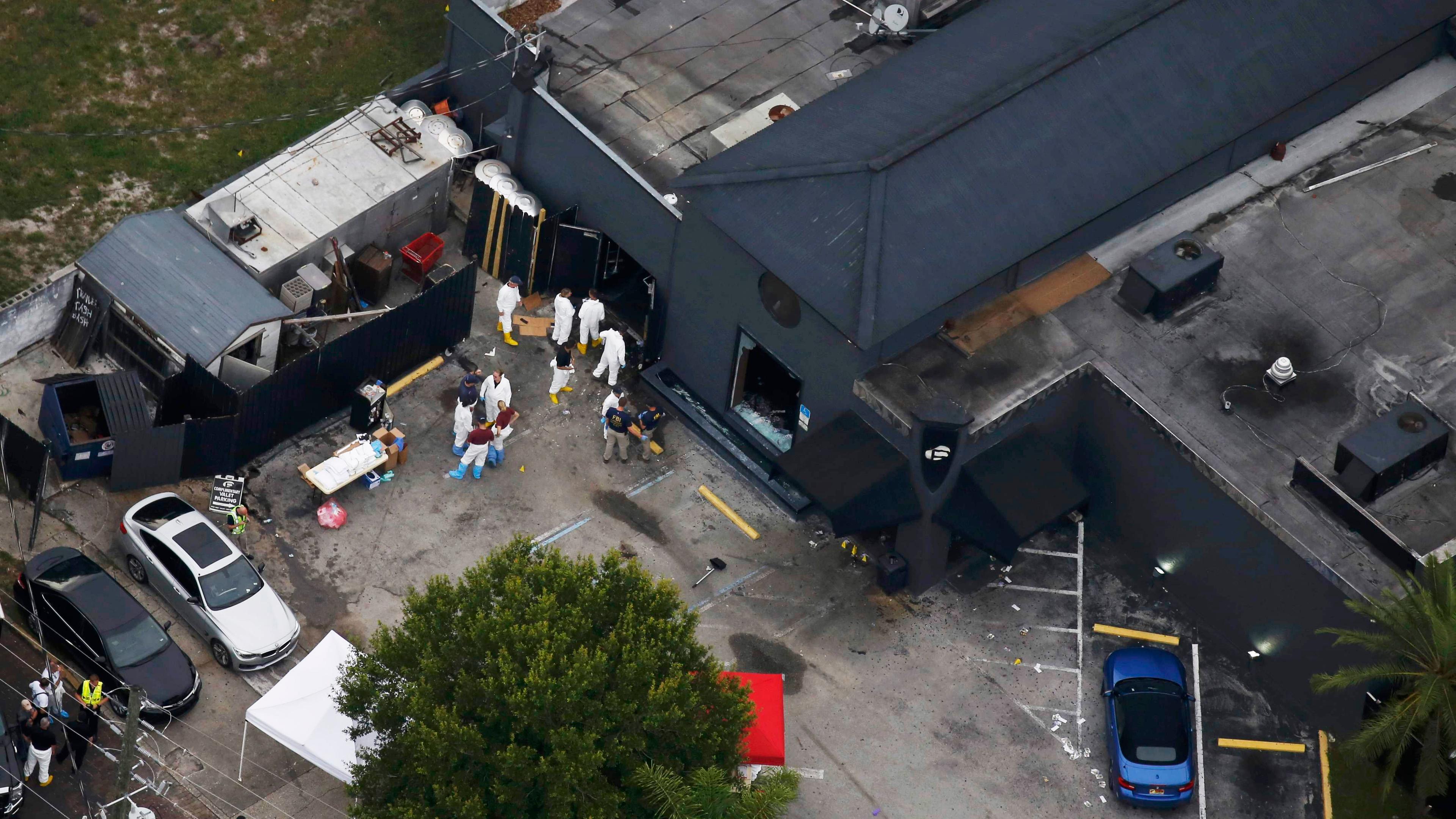 Police and forensics investigators work at the crime scene of the Pulse nightclub shooting in Orlando, Fla., on June 12, 2016.