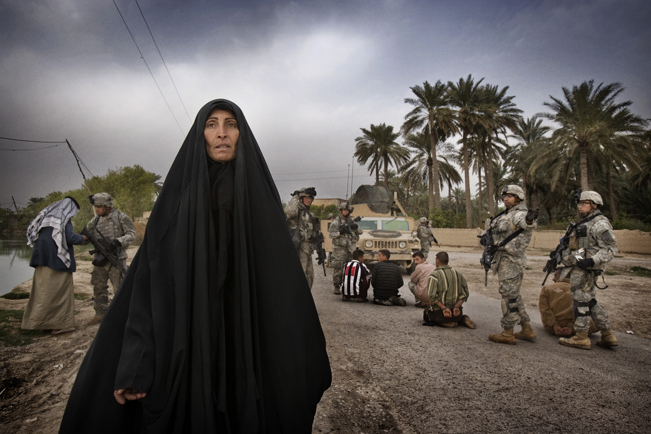 U.S. soldiers from A Troop 5th Squadron 73rd Cavalry detain suspected insurgent sympathizers after killing a militant caught laying a roadside bomb on the outskirts of Baquba. Women from the village begged for the release of the men as U.S. soldiers led 