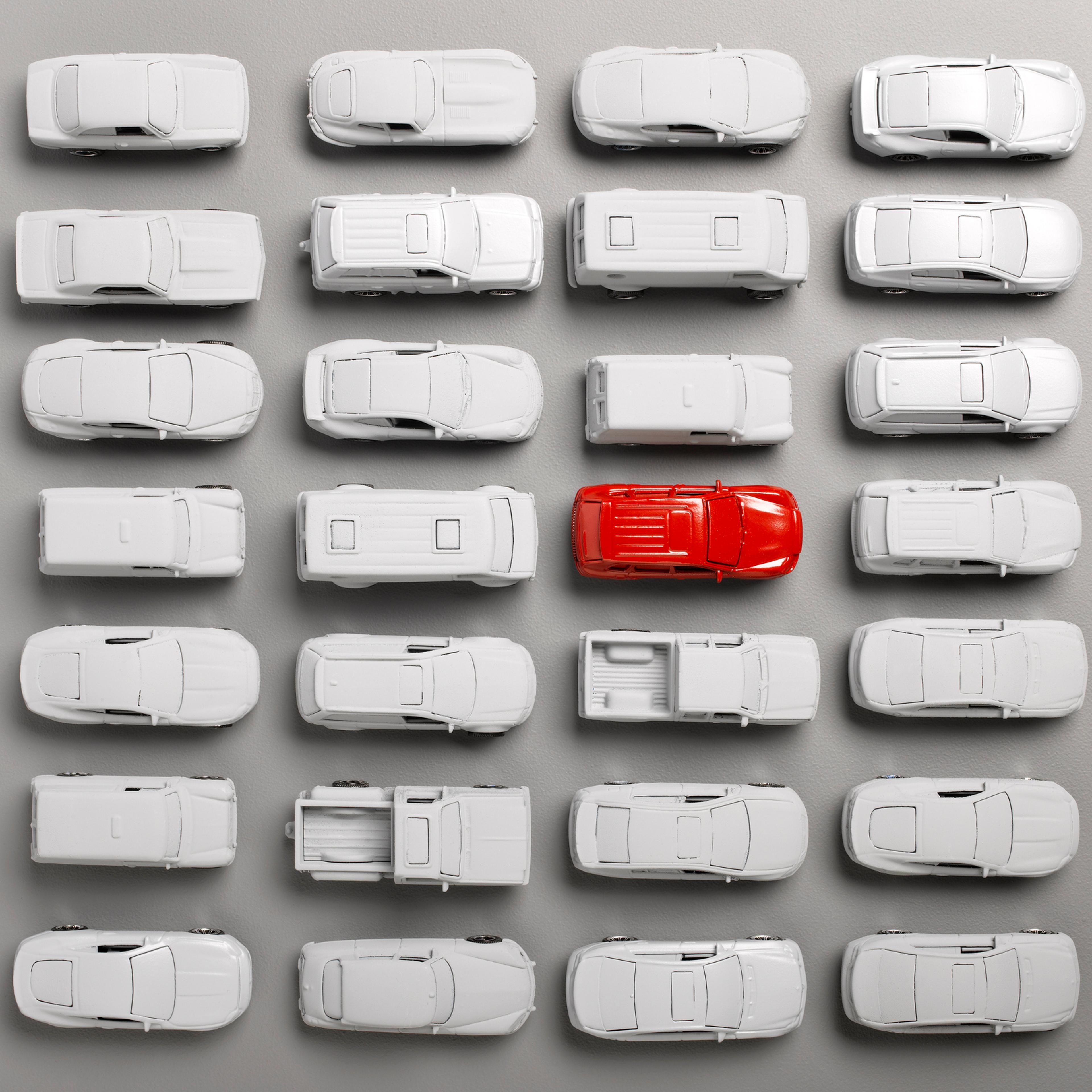 red car surounded by grey cars