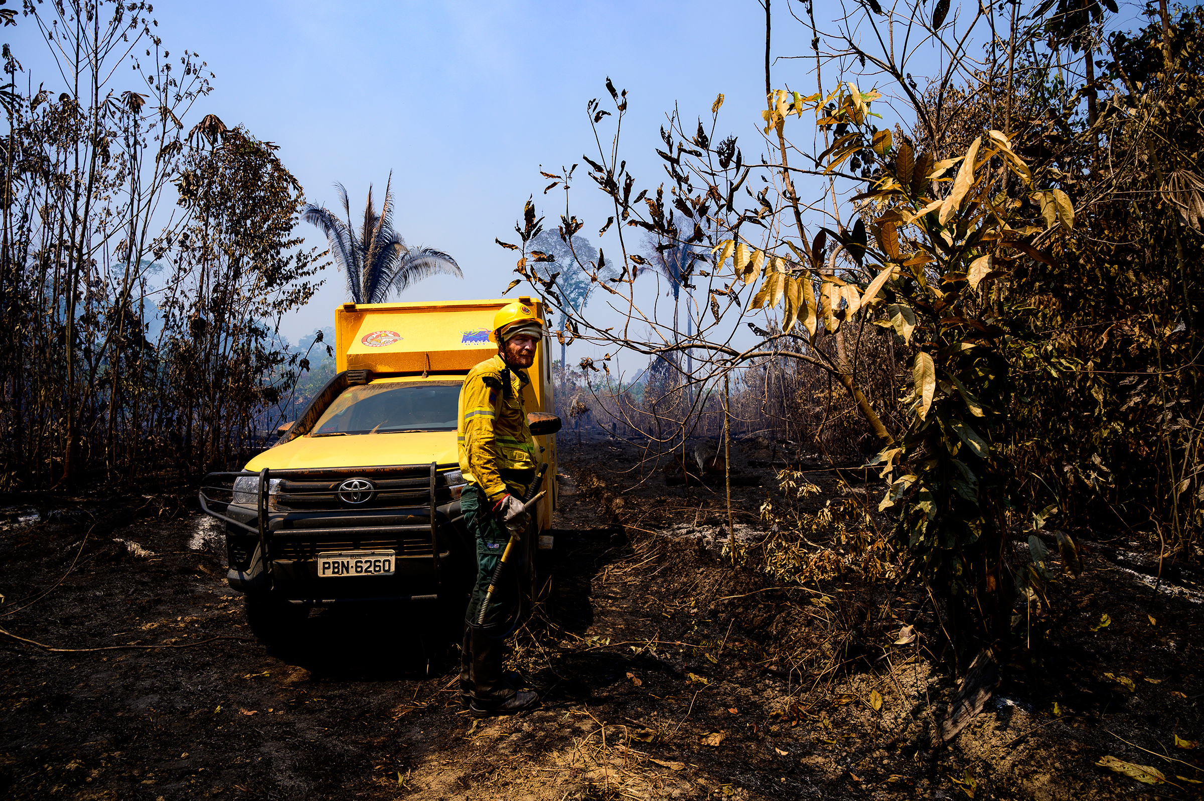 A worker and vehicle from Brazil's environmental agency, IBAMA, in a recently burned forest in the Vila Nova Samuel region on Aug. 28.