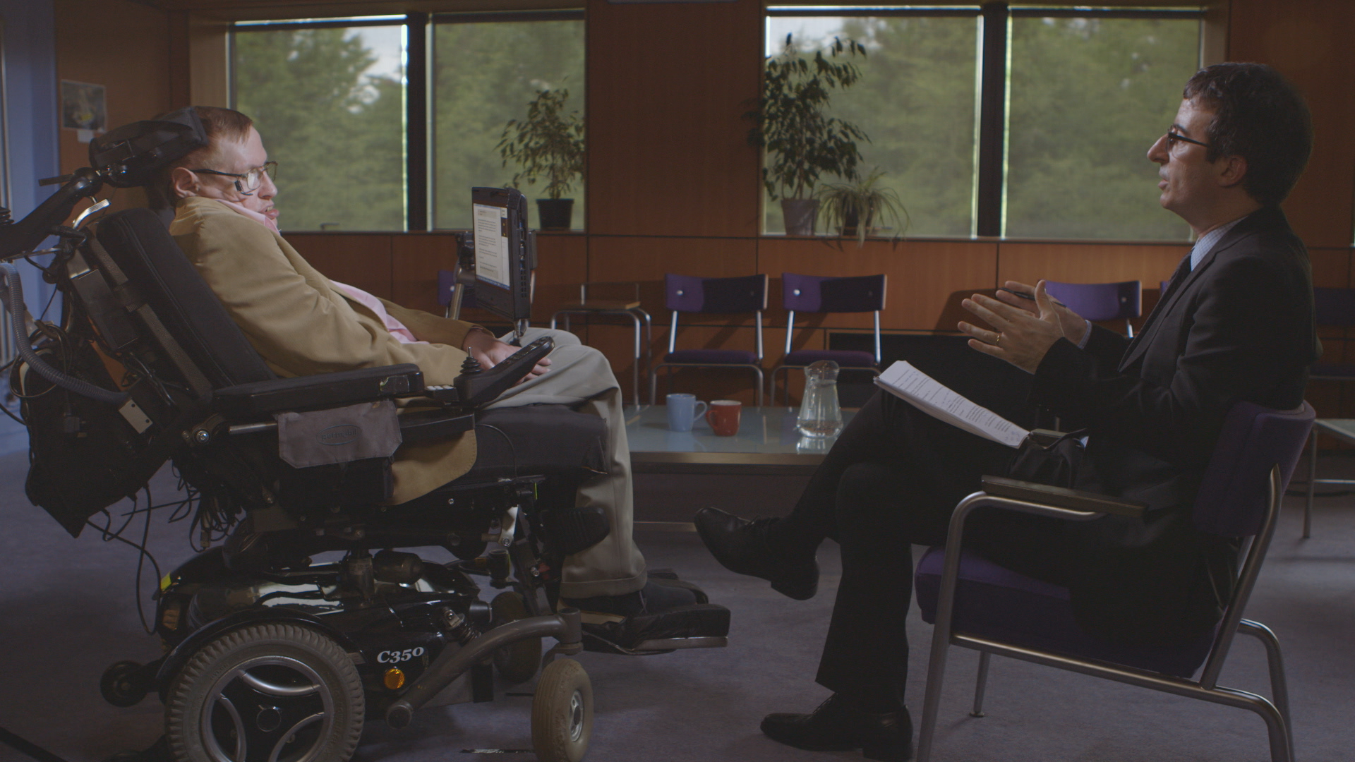 Oliver, at right, interviews Stephen Hawking