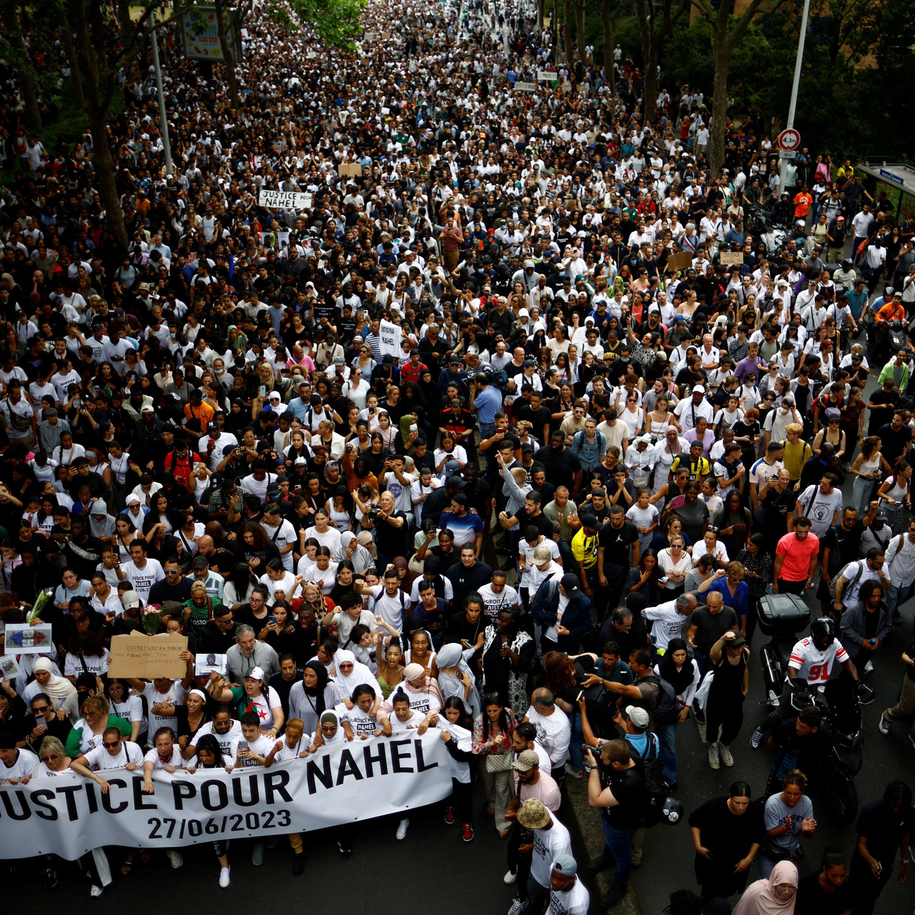People attend a march in tribute to Nahel, a 17-year-old teenager killed by a French police officer during a traffic stop, in Nanterre, Paris, on June 29, 2023. The sign’s slogan reads “Justice for Nahel.”