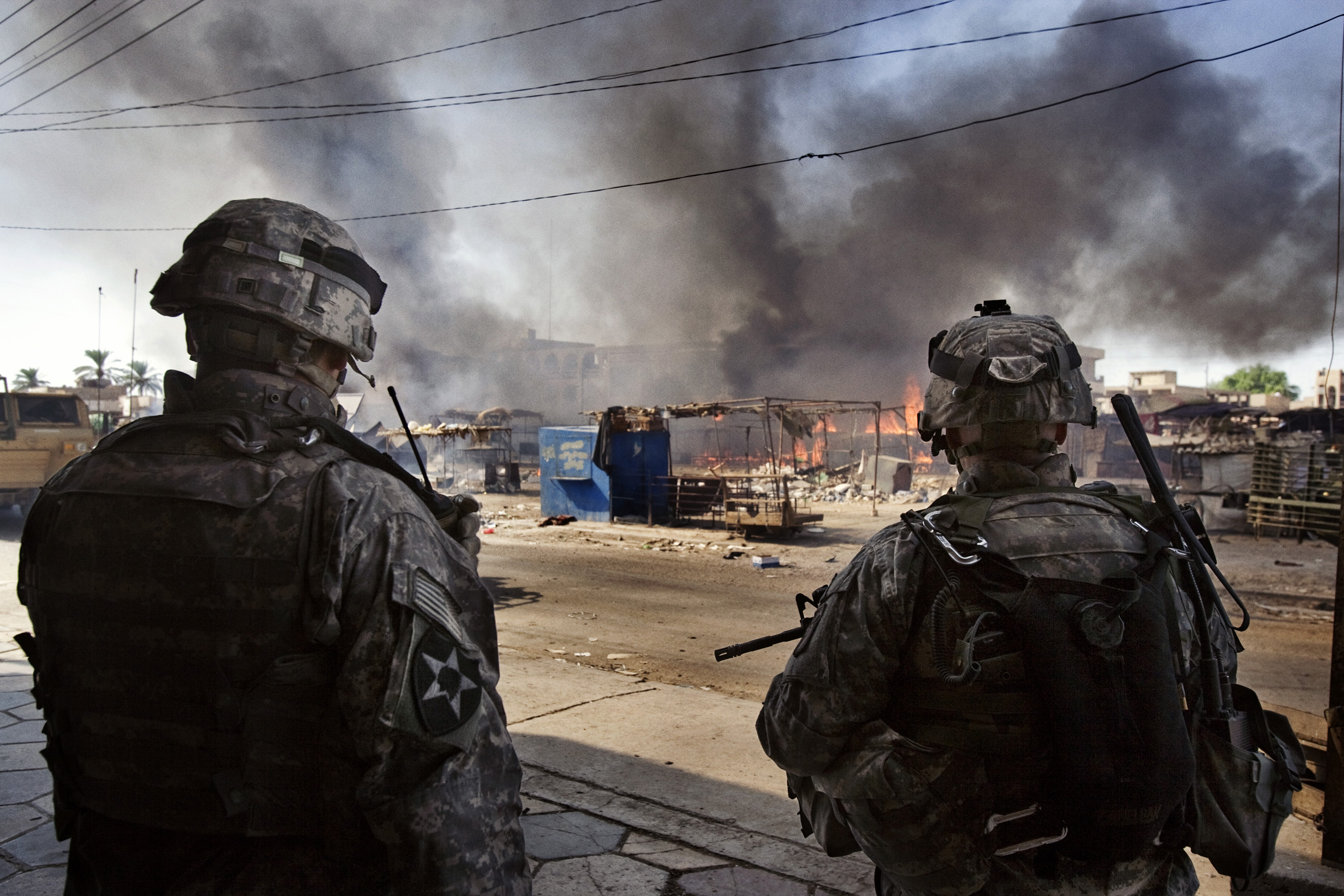 US soldiers of  the 2nd Battalion, 506th INF Regiment 101 Airborne DIV attached to 4th Brigade Combat Team 4th INF DIV  watch a fire  at a market  in Al Dora, a neighborhood controlled by Sunni extremists, Baghdad, Iraq, Sept. 28, 2006.