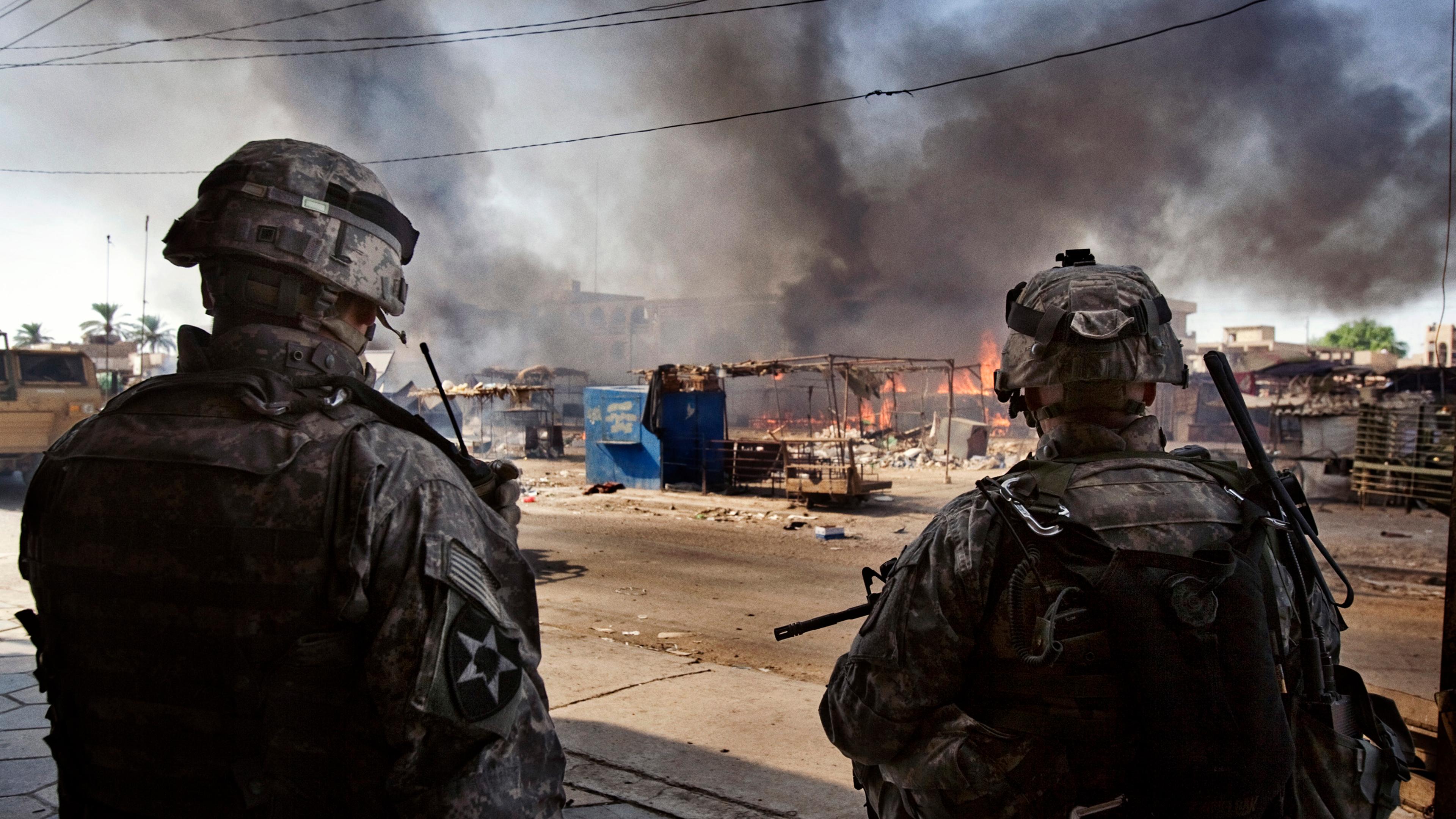 US soldiers of the 2nd Battalion, 506th INF Regiment 101 Airborne DIV attached to 4th Brigade Combat Team 4th INF DIV watch a fire at a market in Al Dora, a neighborhood controlled by Sunni extremists, Baghdad, Iraq, Sept. 28, 2006.