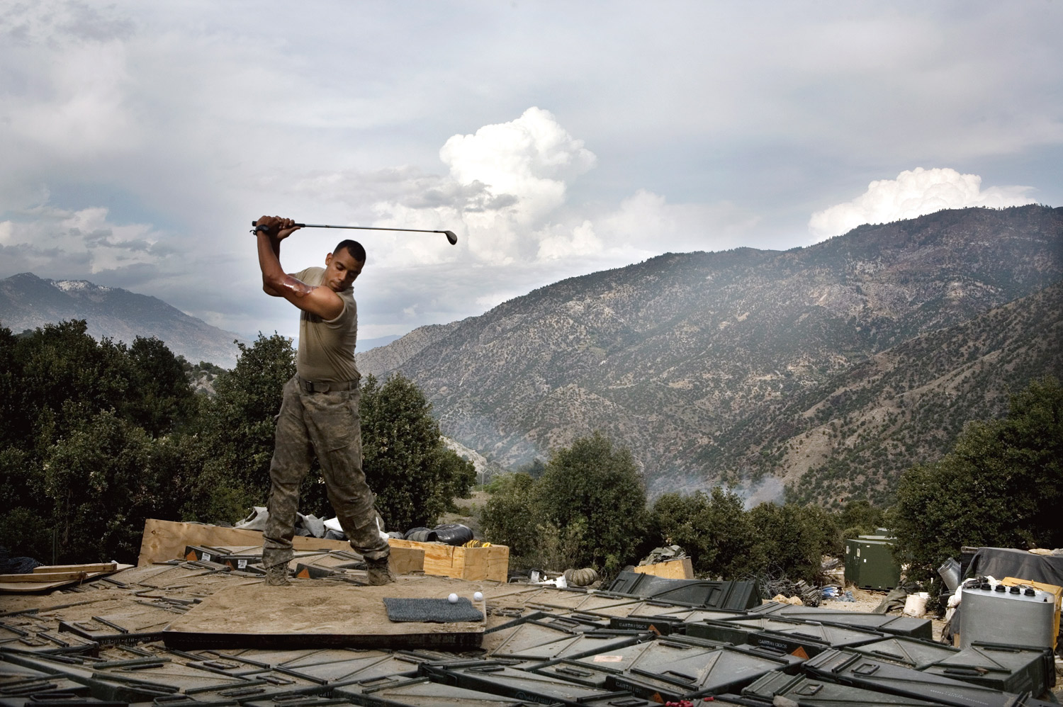 US Army soldier Jones practices his golf swing while at the main firebase in the Korengal Valley, Afghanistan.